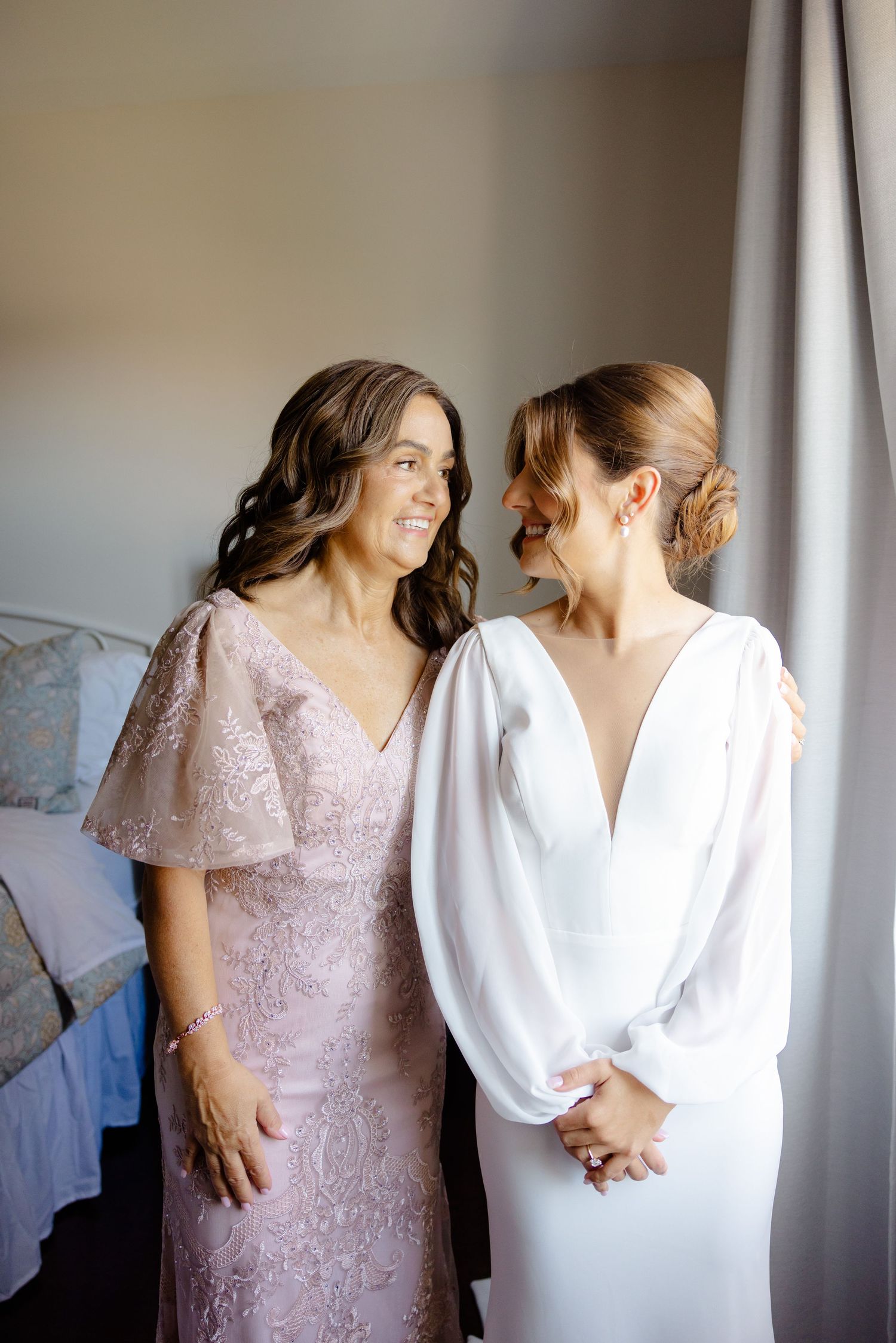 Wedding day preparation scene with two dresses - one white and one blush pink lace.