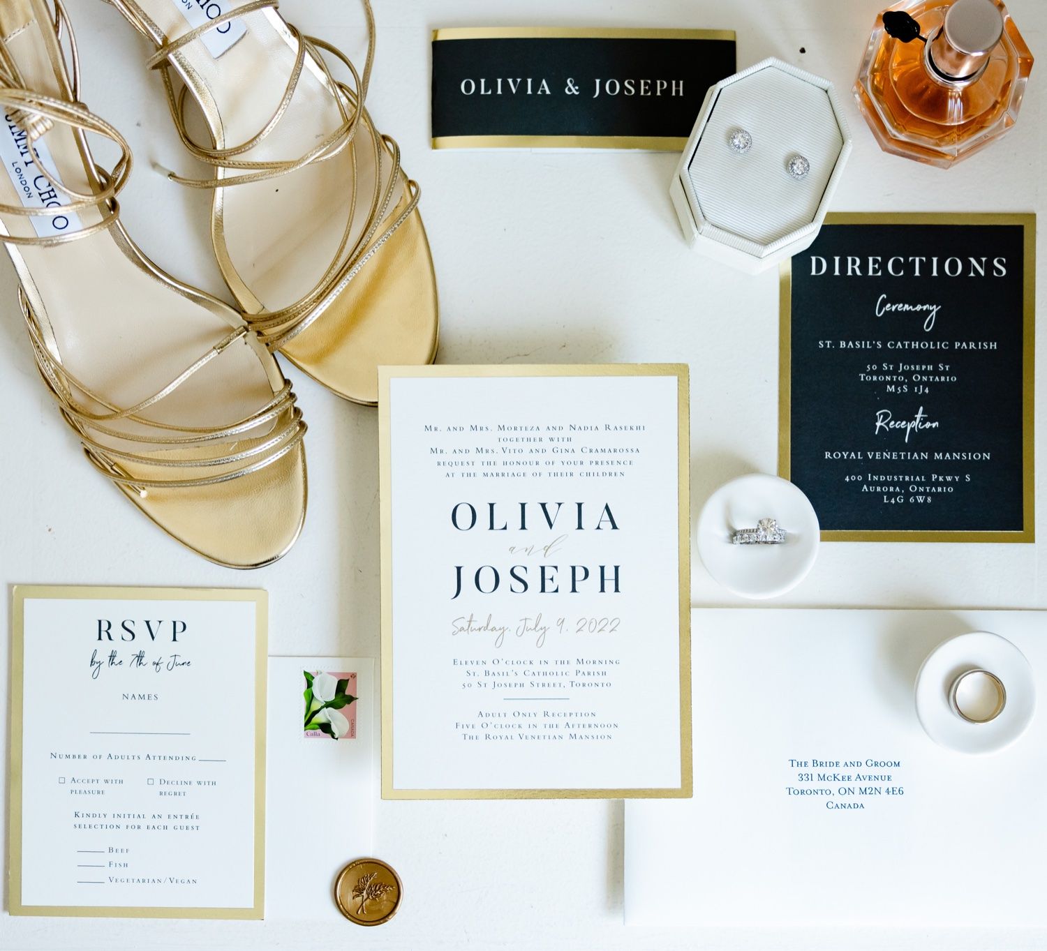 Modern wedding stationery set with black and gold details alongside golden heels.