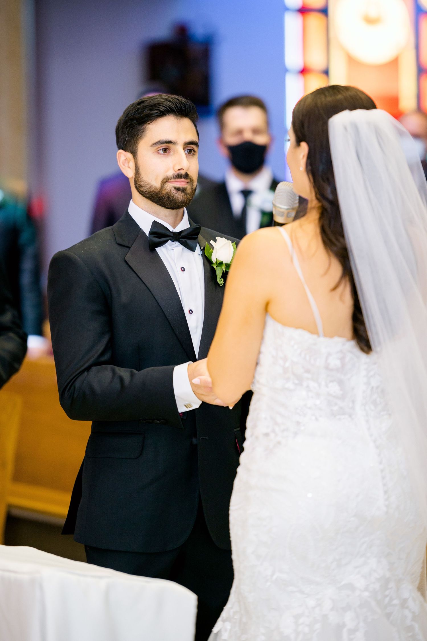 A tender moment between the bride and groom during their wedding ceremony in a church.