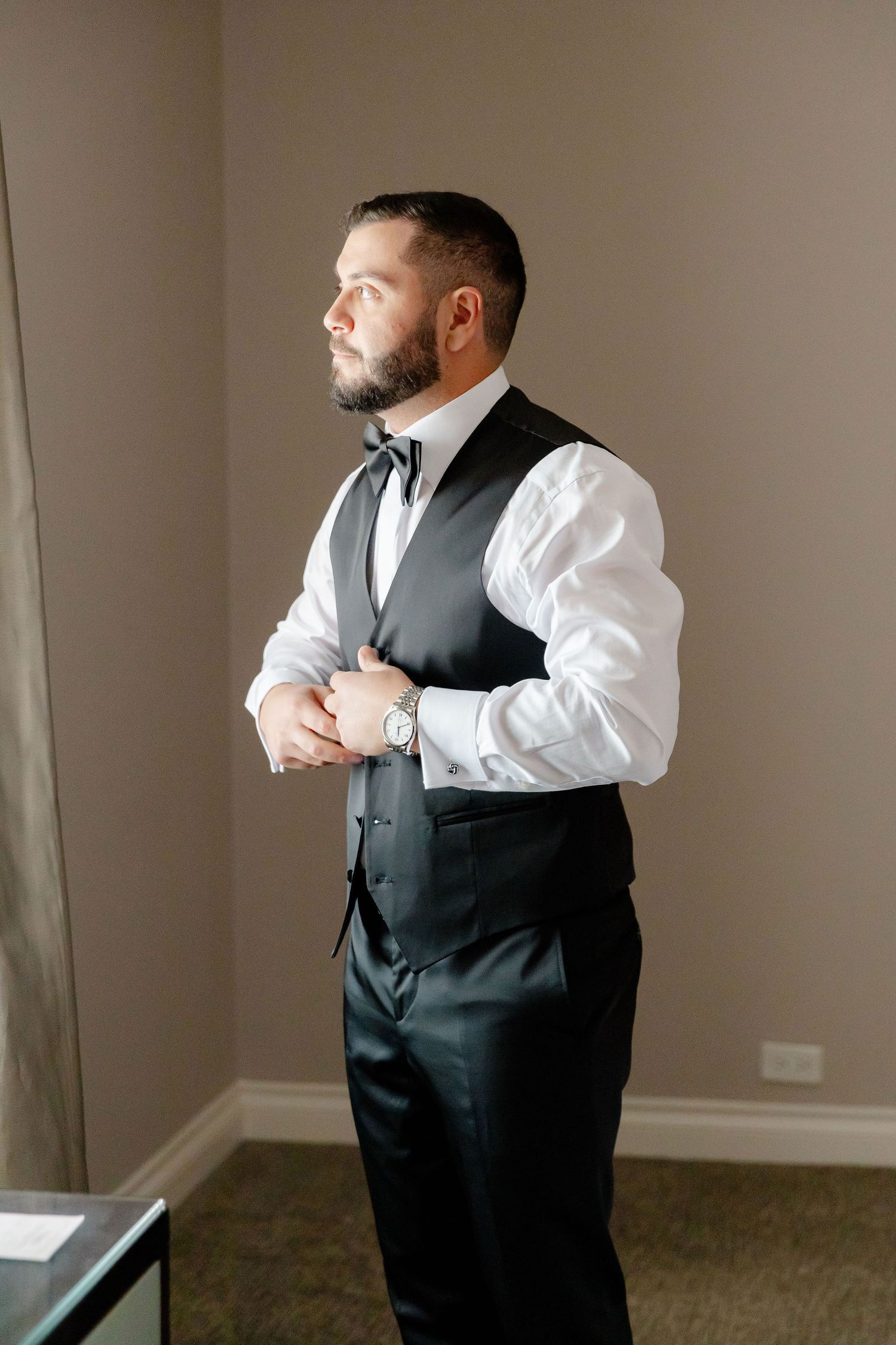 A series of photos showing a man in formal attire adjusting his black vest and white dress shirt.