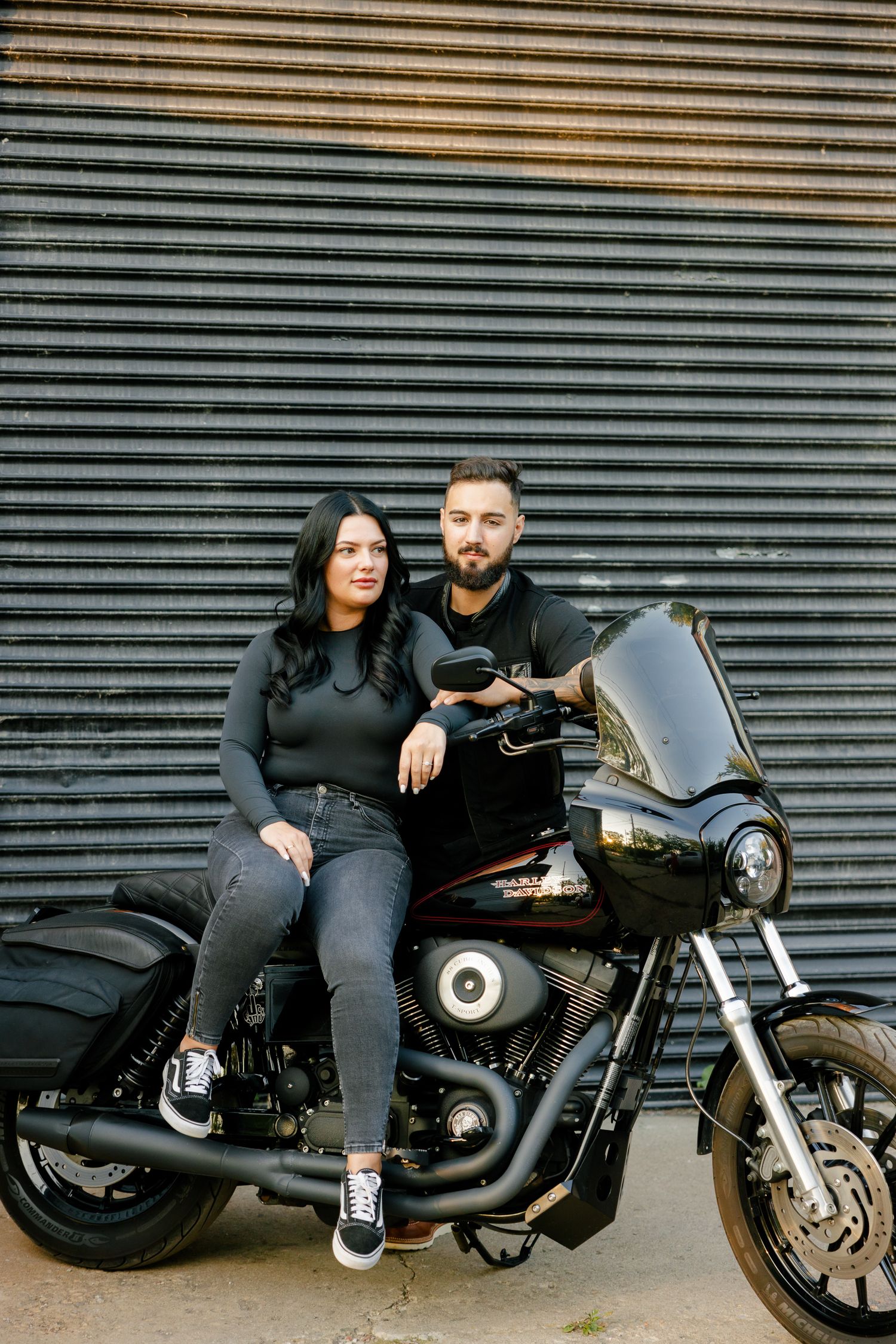 Stylish motorcycle portrait against industrial metal backdrop.