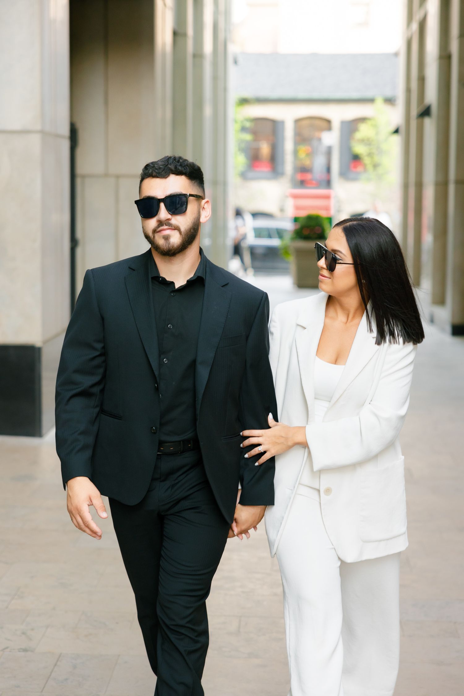 Modern couple walking through urban setting in black and white formal wear.