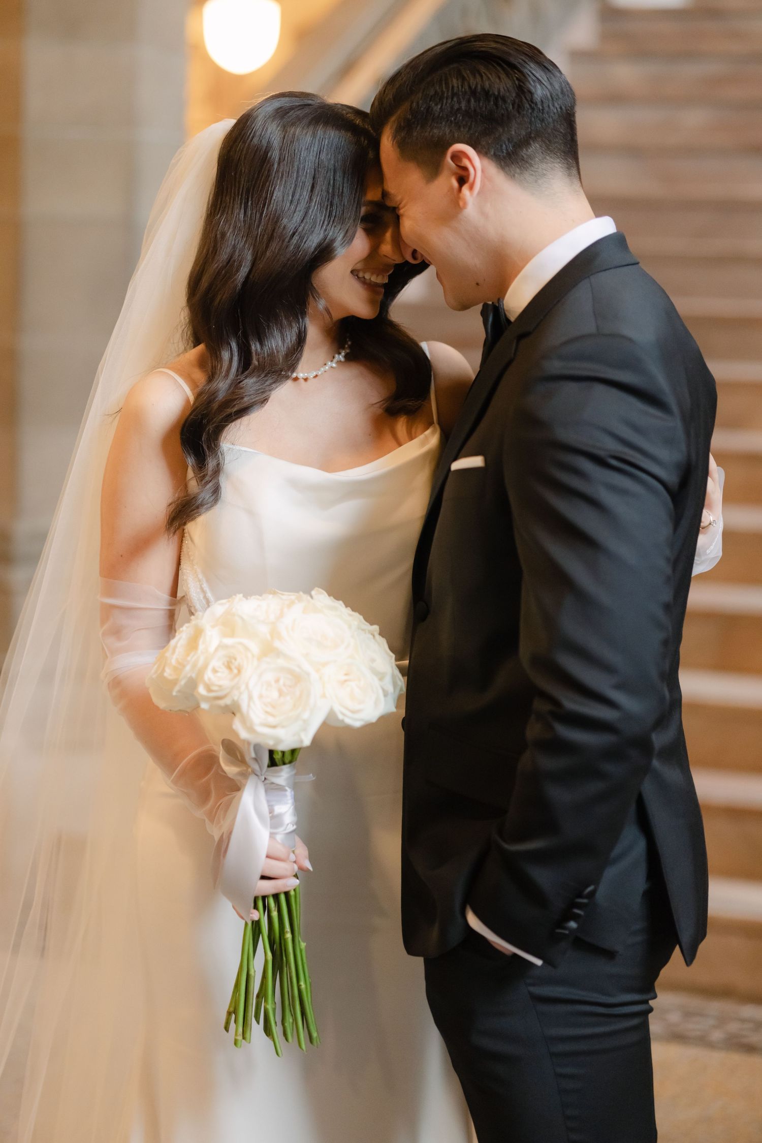 A close romantic moment captured with a white rose bouquet and flowing veil.