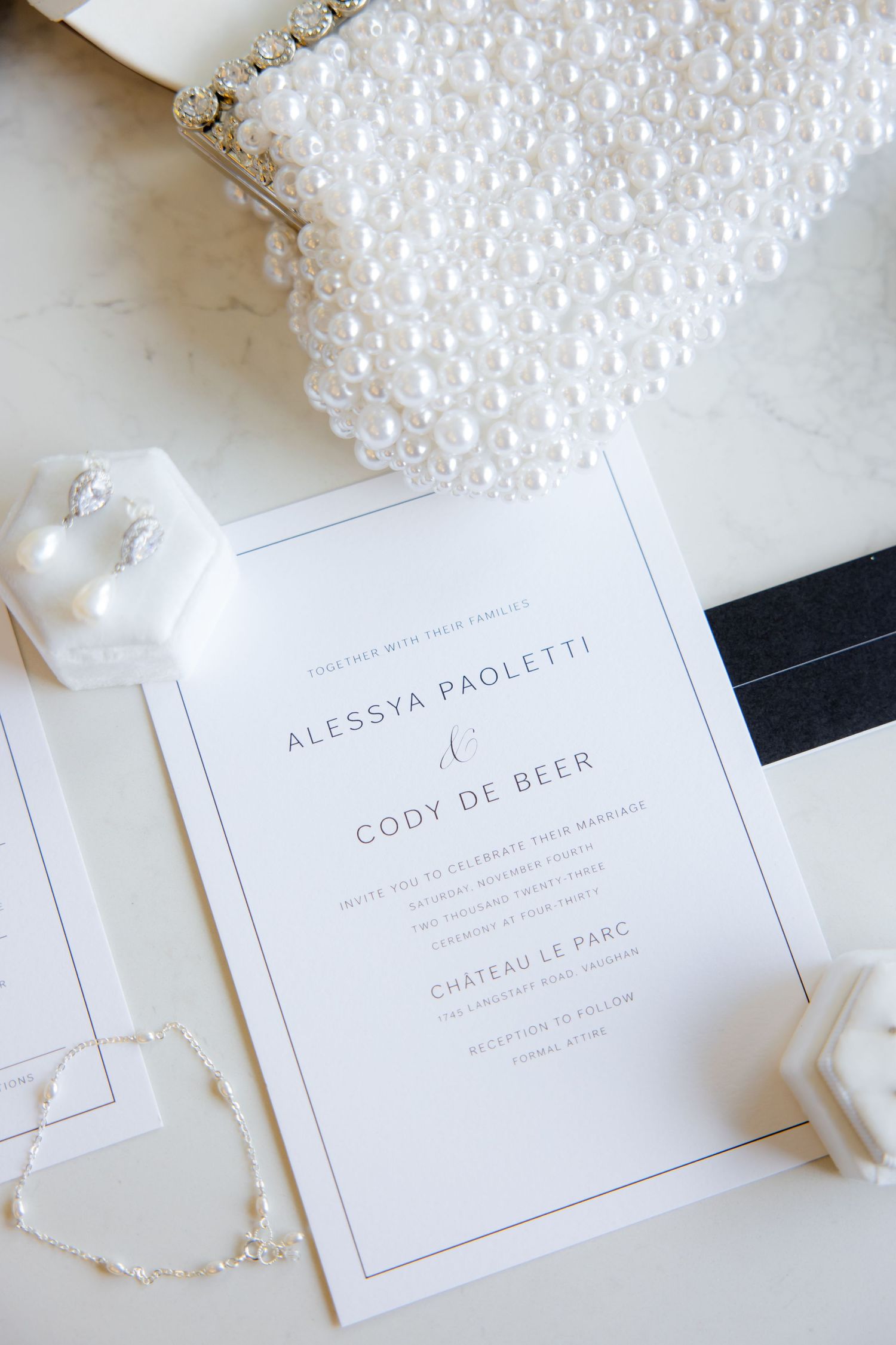 Minimalist wedding invitation with pearl clutch and hexagonal jewelry box.