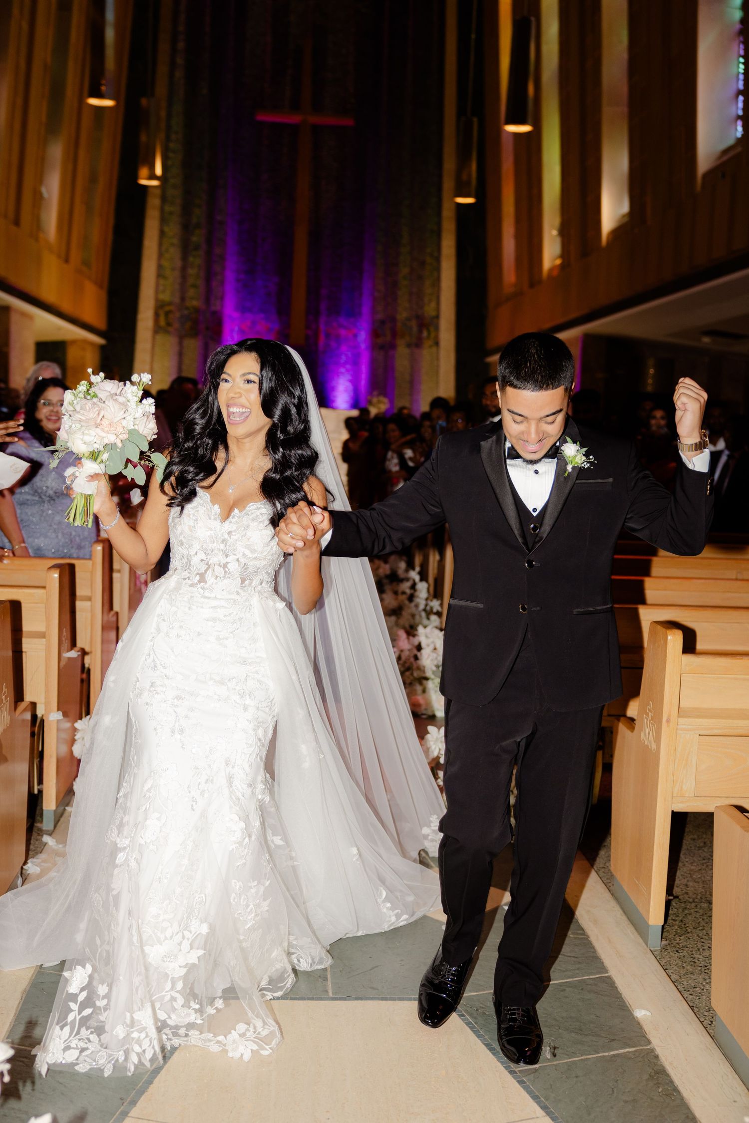 A celebratory exit down a church aisle with the couple showing pure joy.