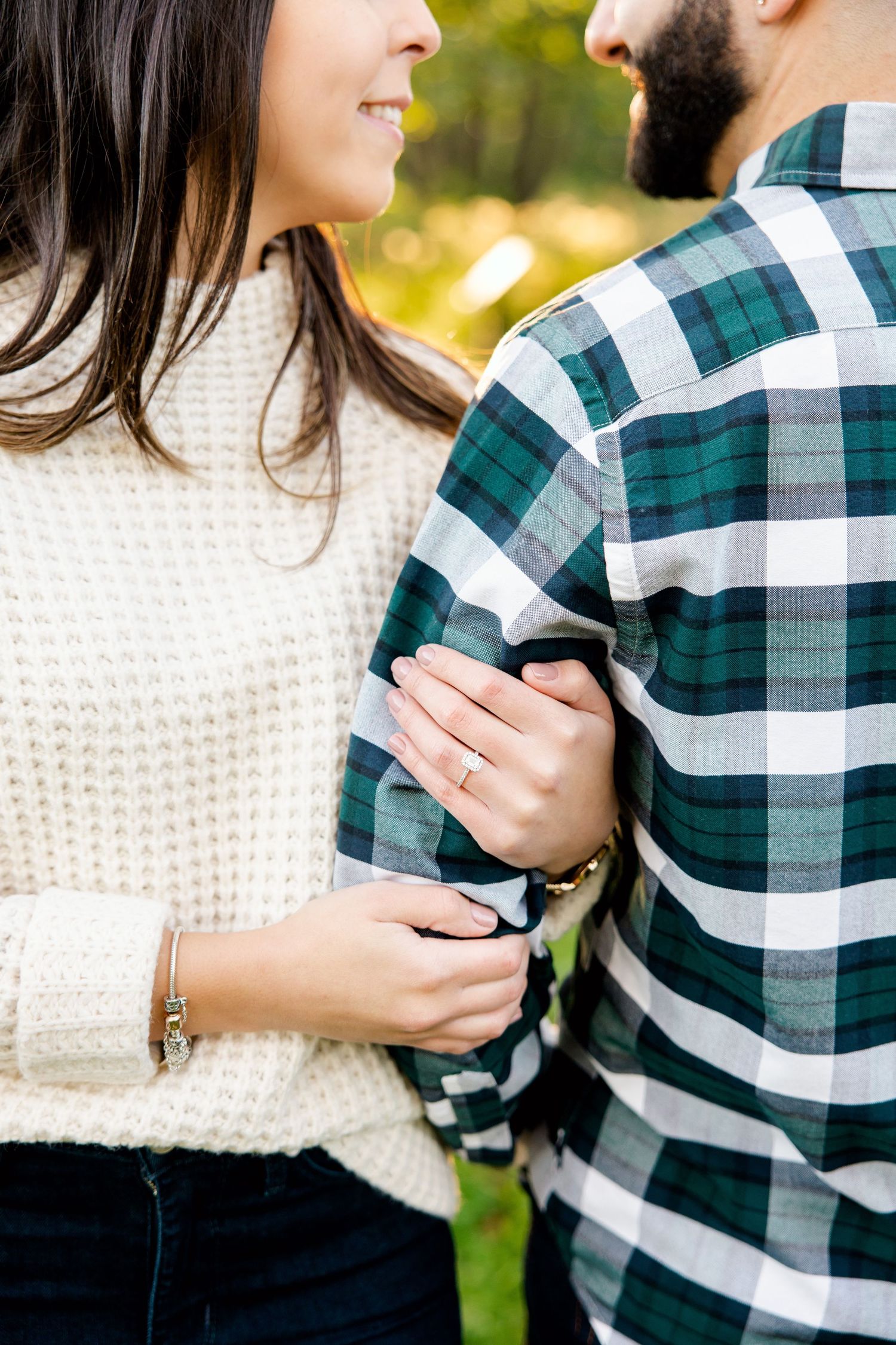 Close up of couple in plaid shirt and cream sweater showing tender moment.