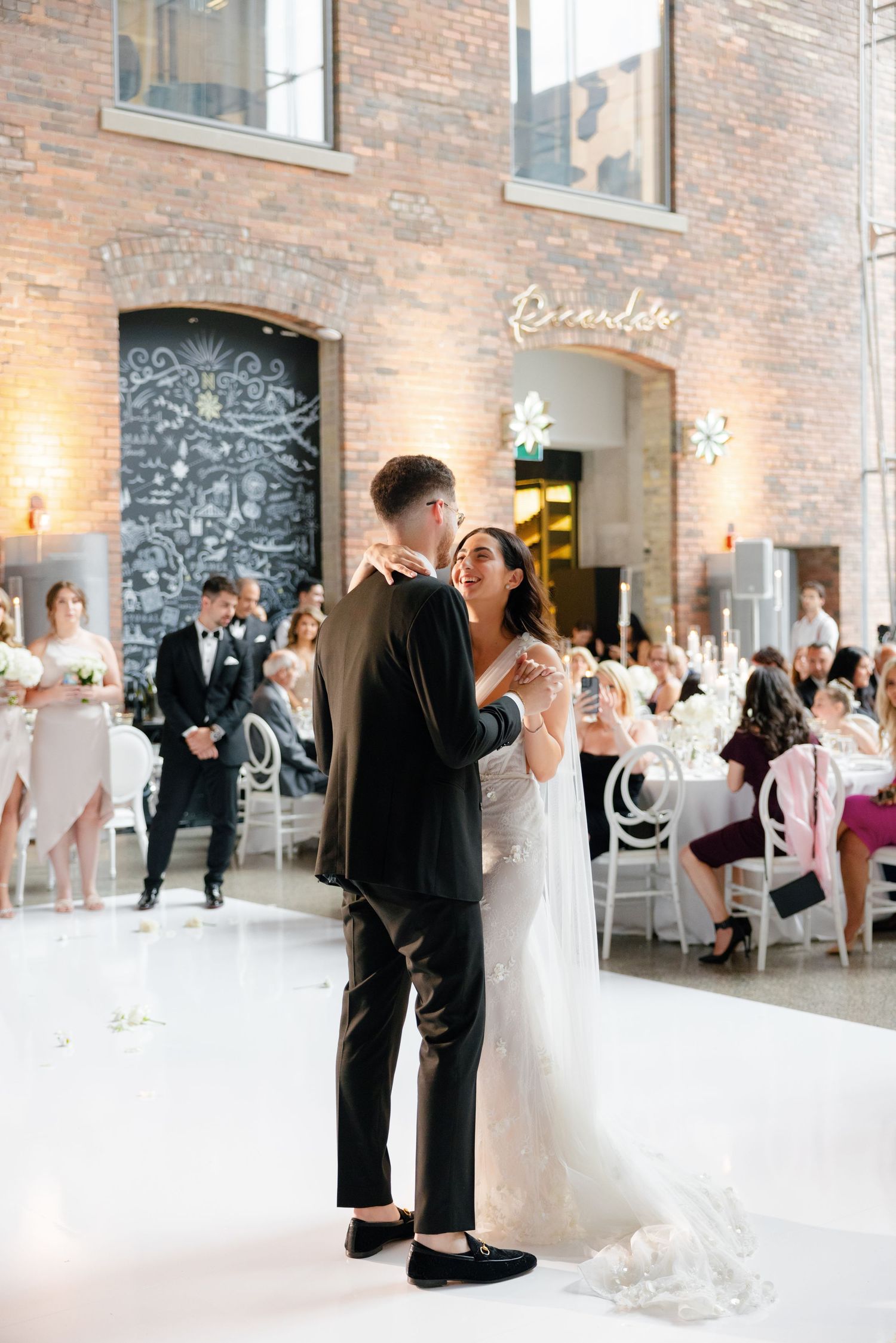 Wedding celebration in industrial venue featuring exposed brick walls and decorative chalkboard details.