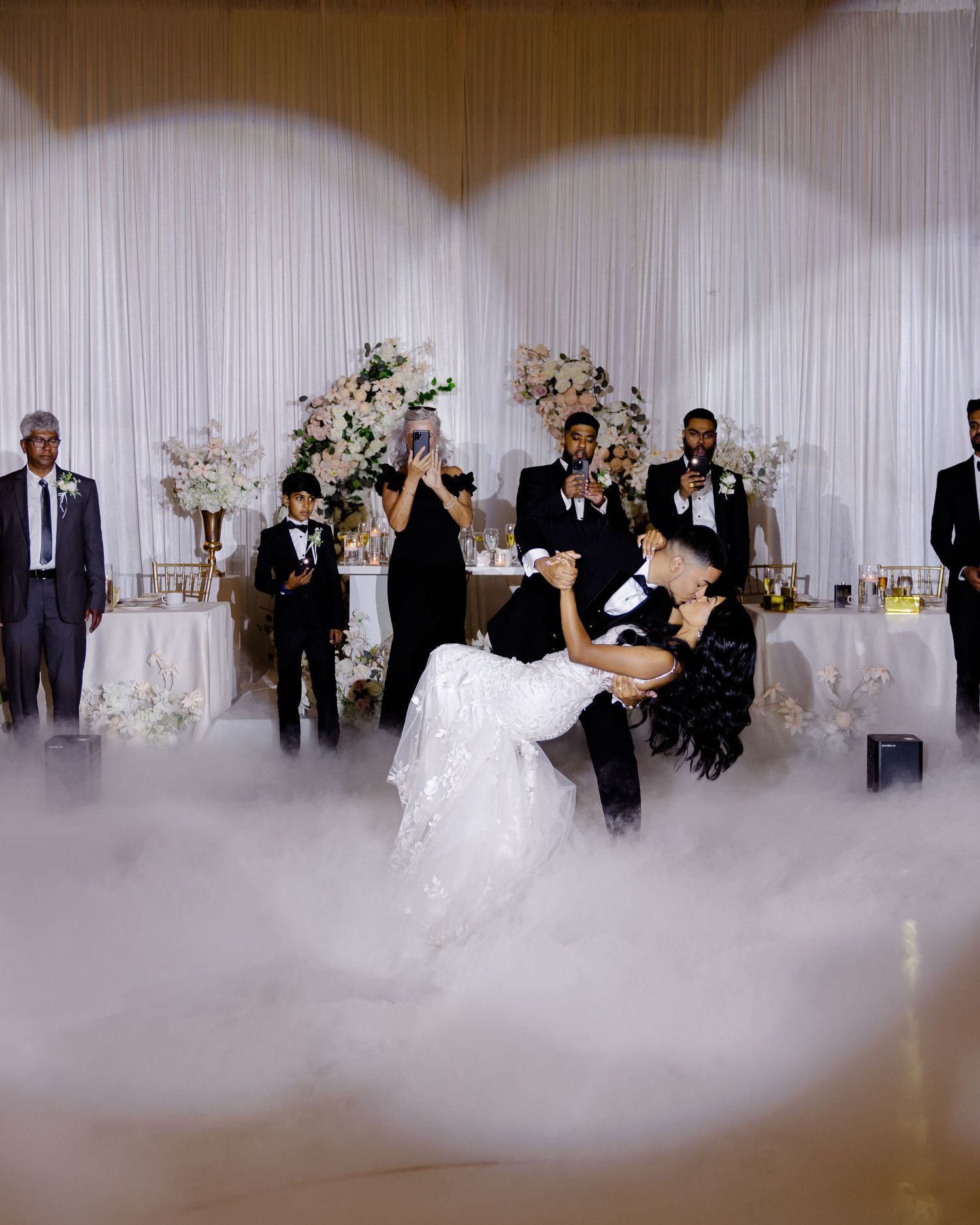 A romantic dip during the first dance at a wedding reception with fog effects on the dance floor.