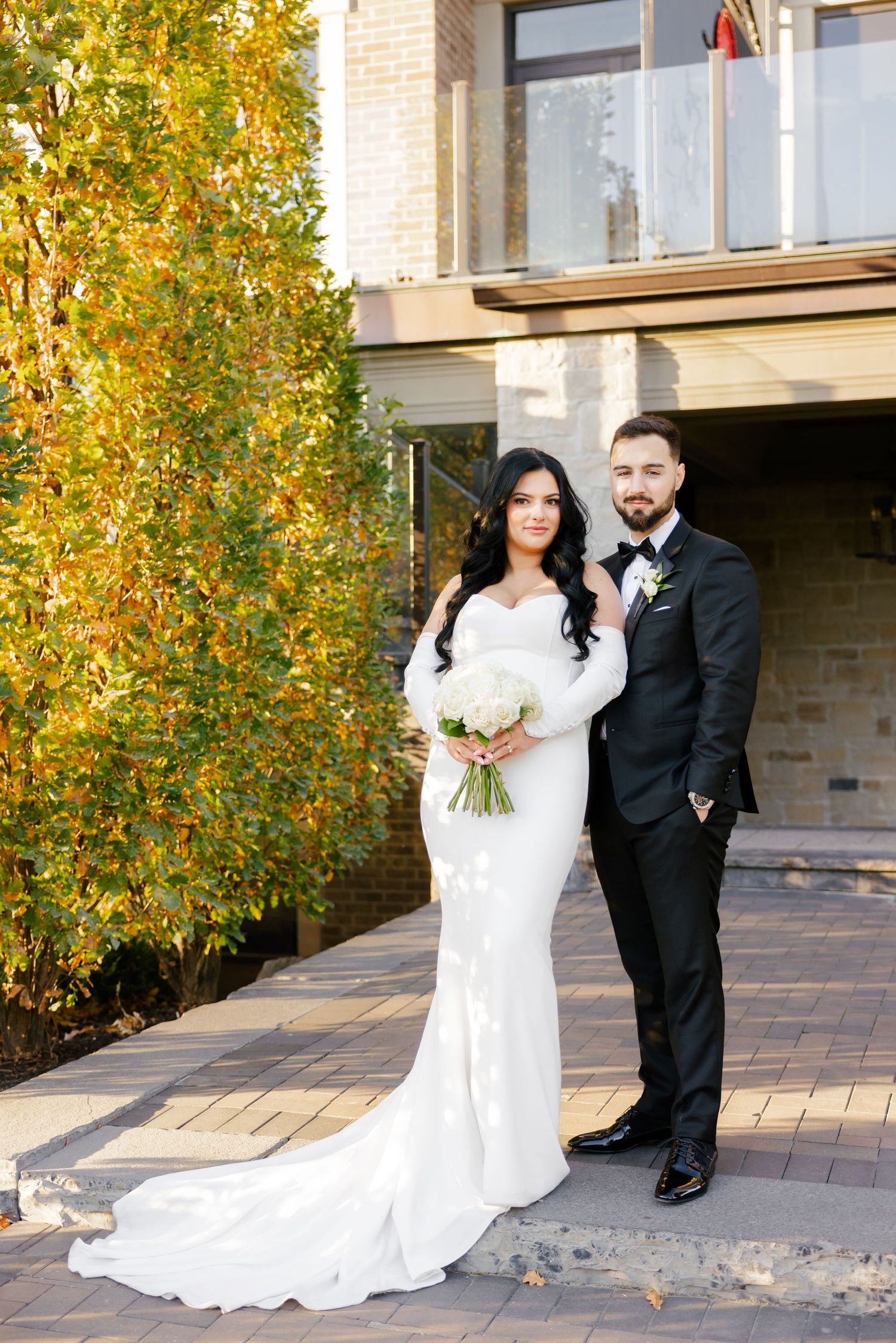 Formal wedding portrait with autumn colors and classic architecture.