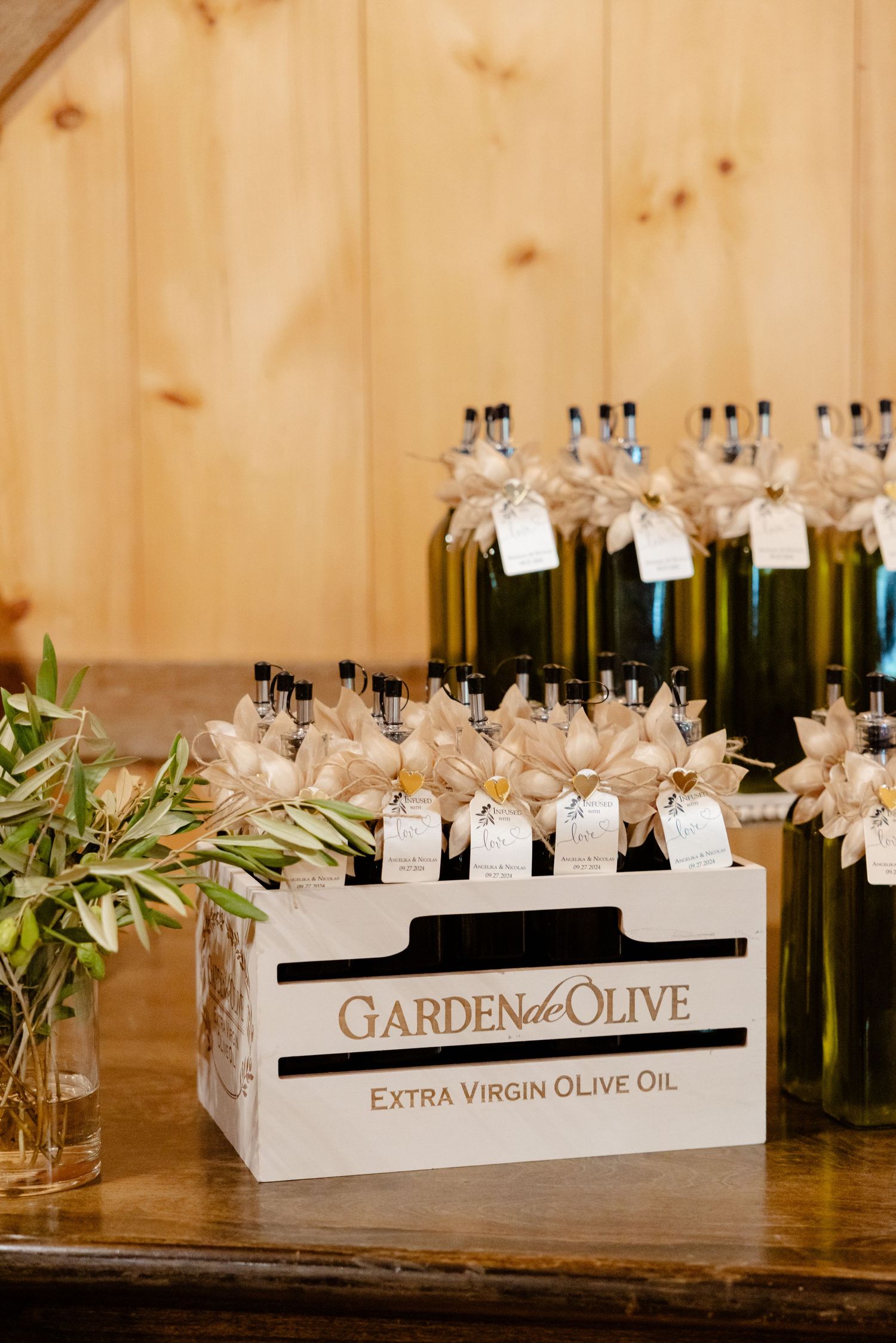 Bottles of Garden of Olive extra virgin olive oil arranged in wooden crates as wedding favors.