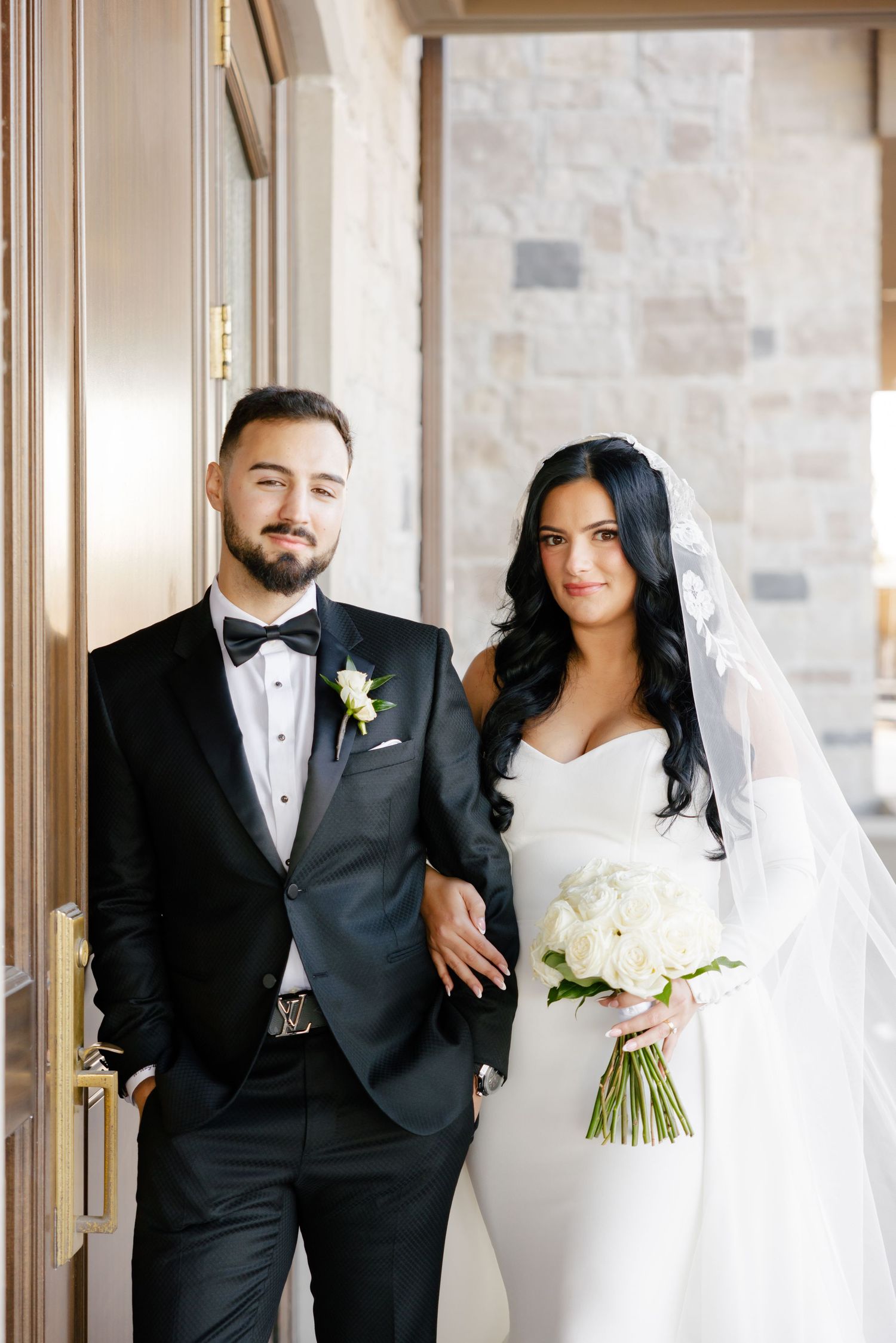 Formal wedding portrait featuring couple in timeless black and white attire.