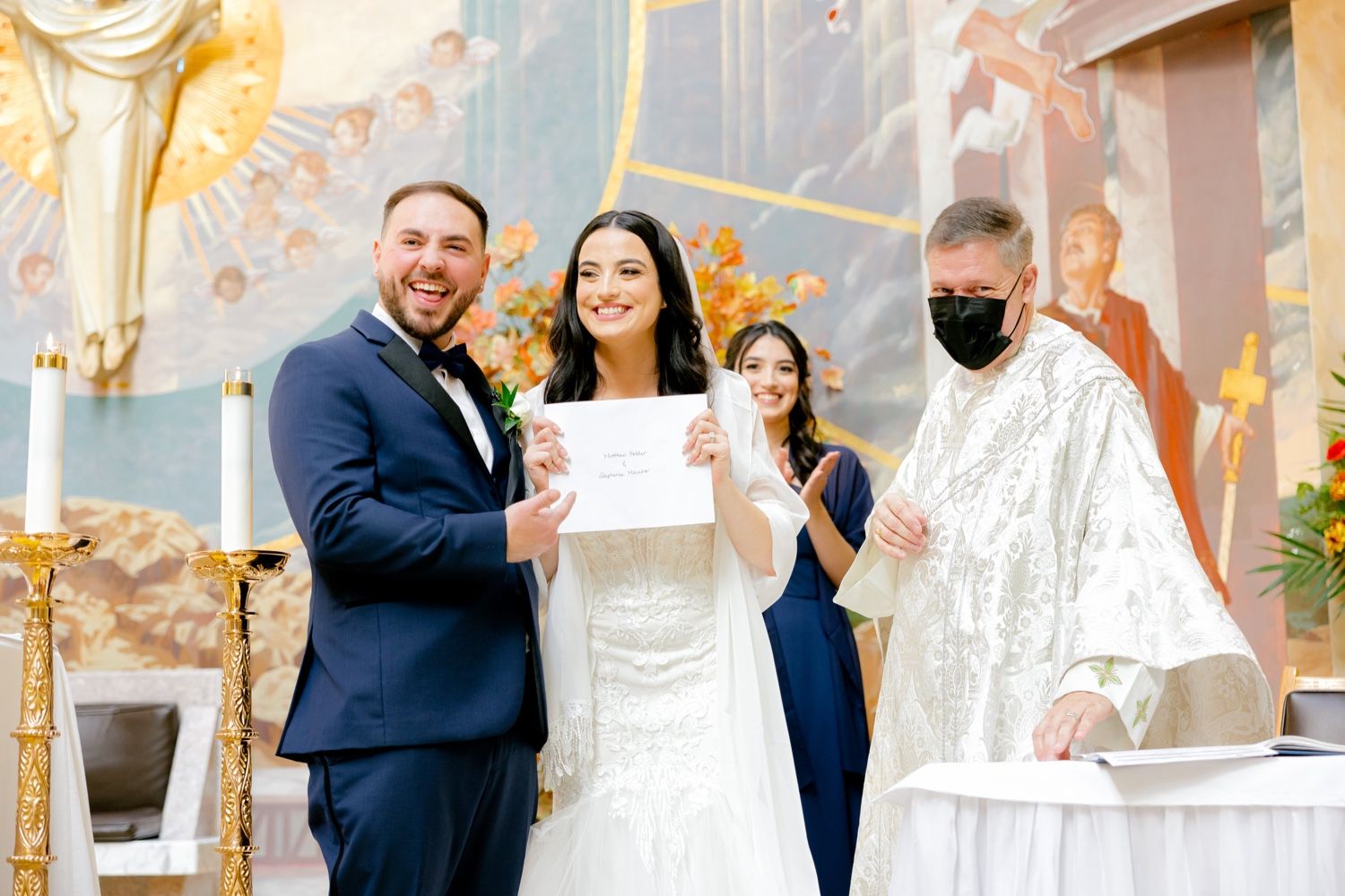 A wedding ceremony takes place in an ornate church with golden decorations and religious artwork.