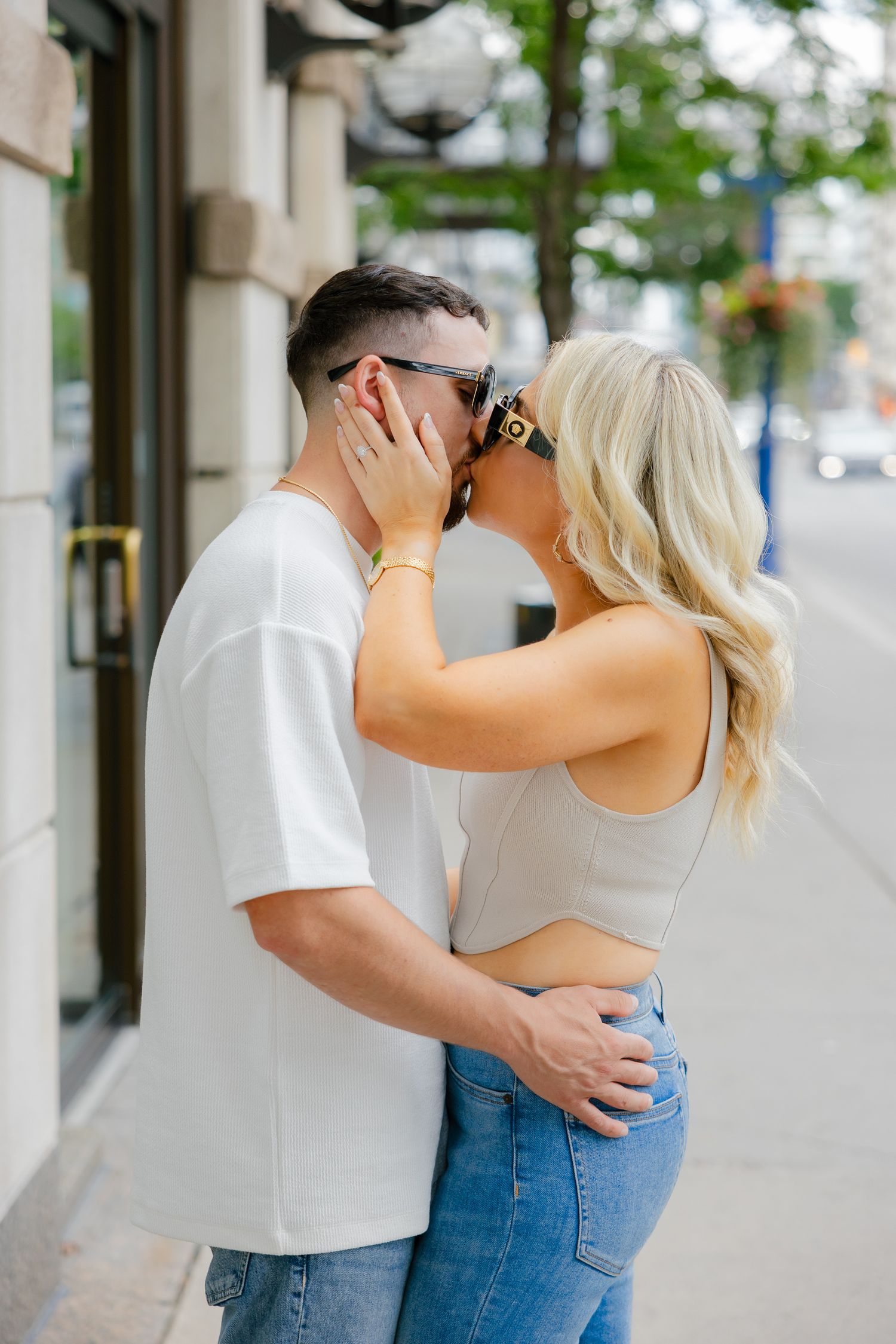 A romantic moment between a couple outside a shop with decorative lanterns.