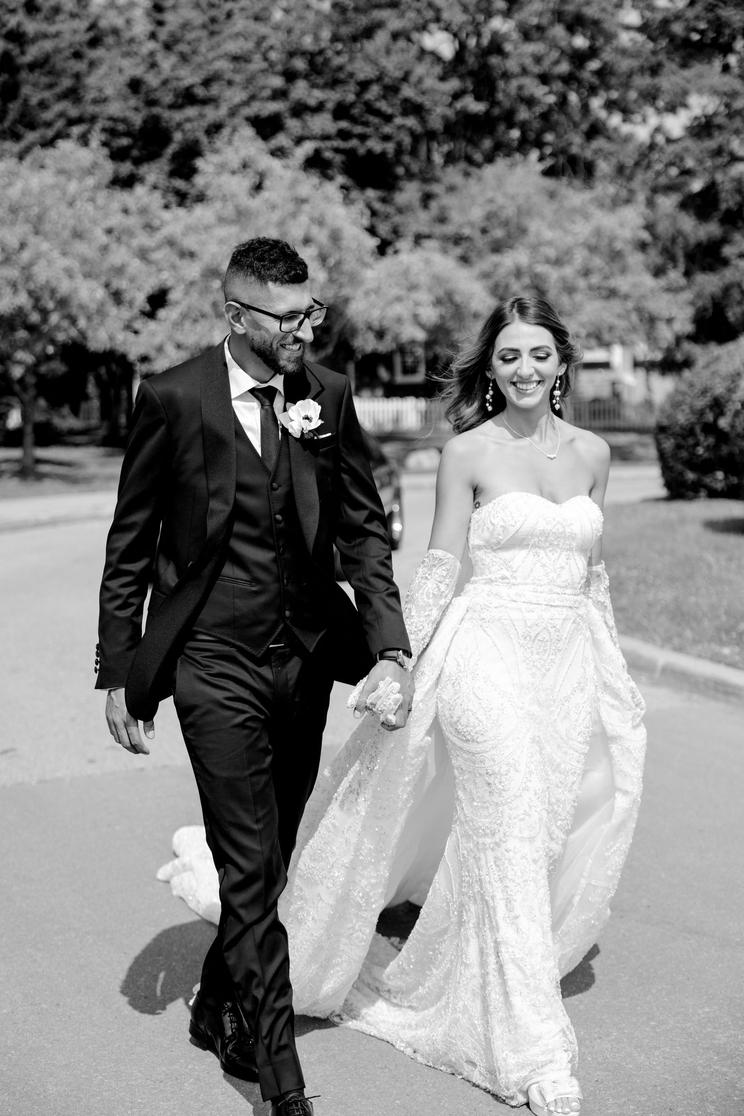 Black and white portrait of newlyweds walking together on their wedding day.