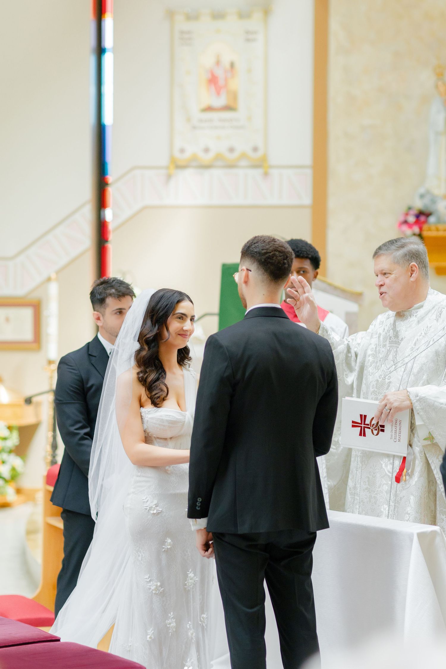 A Catholic wedding mass in progress with the priest performing the ceremony rituals.