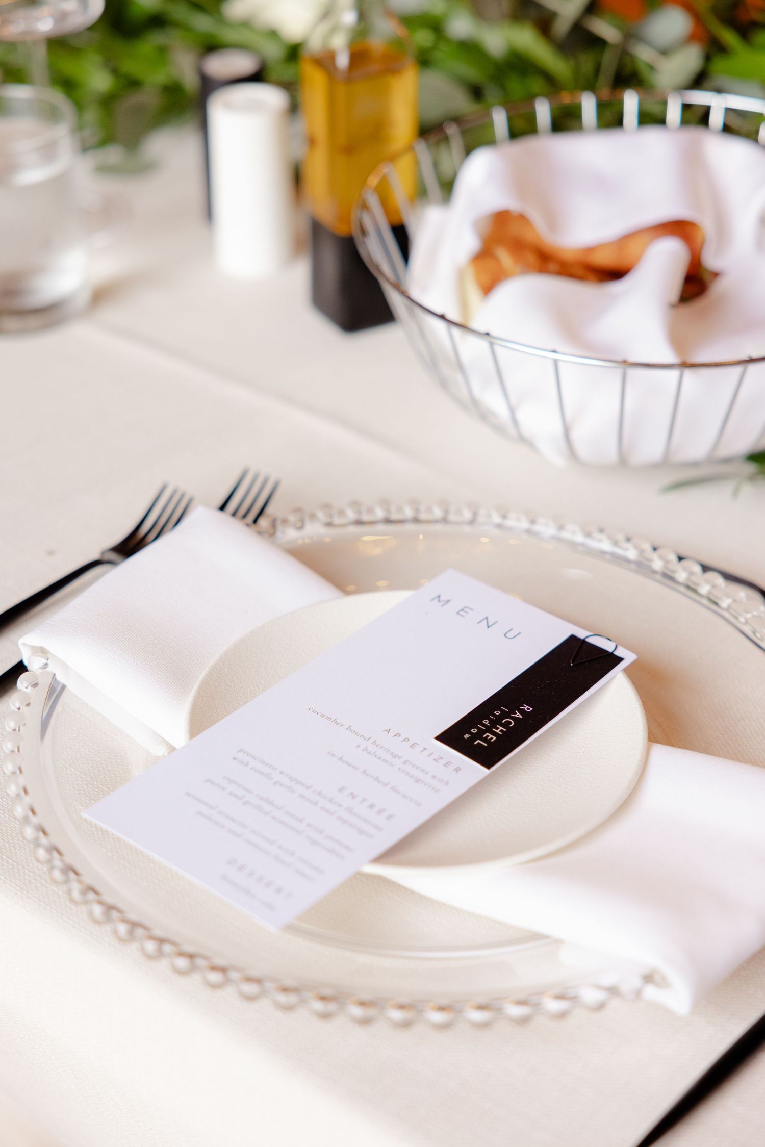 Close-up of formal place setting with menu card and beaded charger plate at wedding reception.