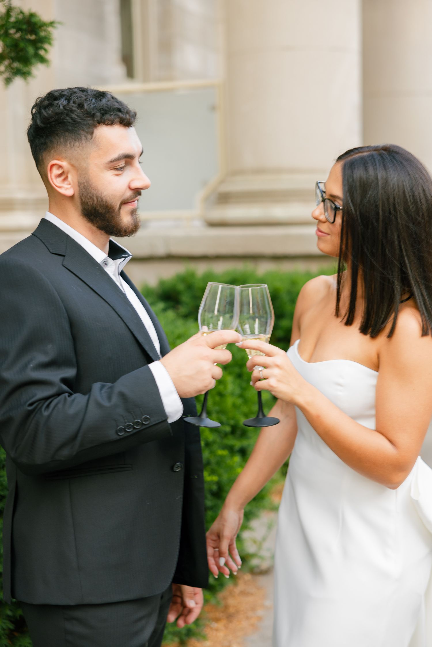 Couple sharing an intimate moment while toasting with wine glasses outdoors.