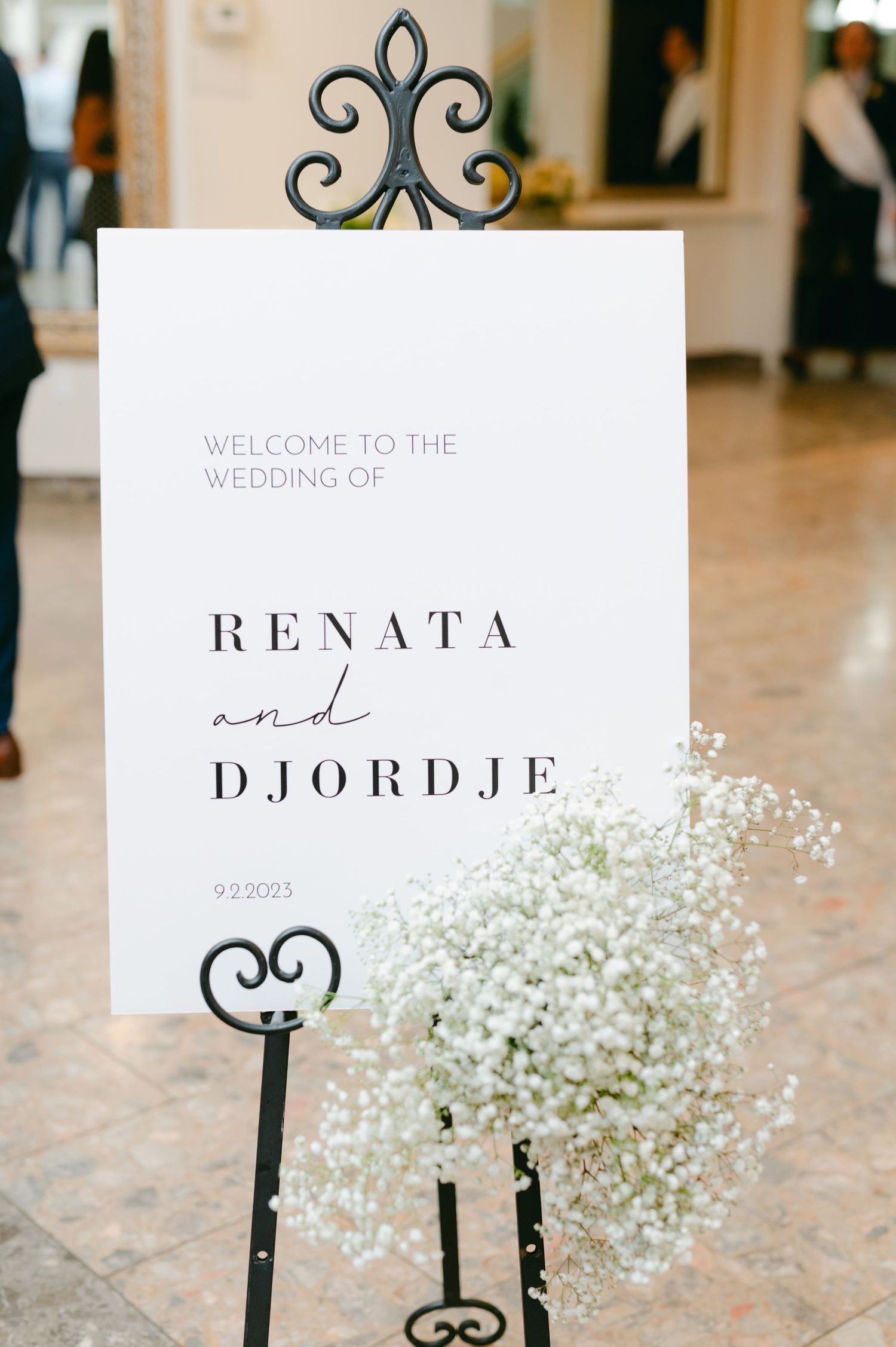 Elegant wedding welcome sign with couple's names Renata and Djordje decorated with baby's breath flowers.
