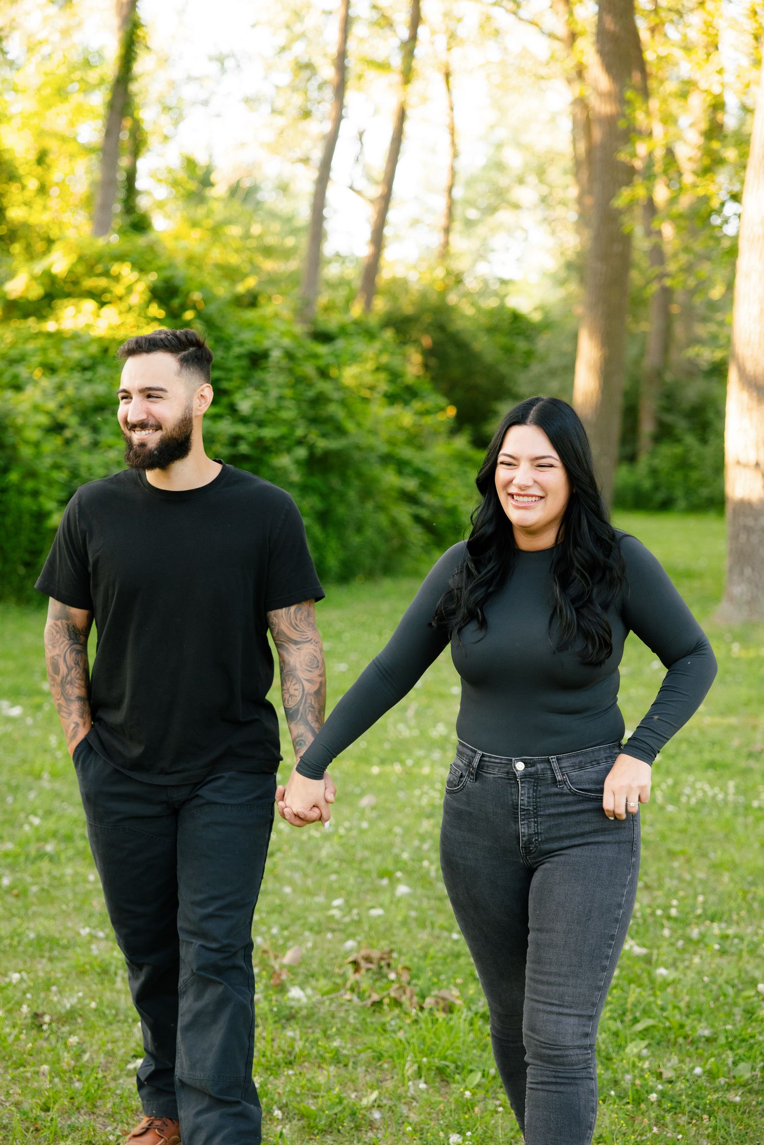 A couple shares a joyful moment while walking together in a sunlit park.