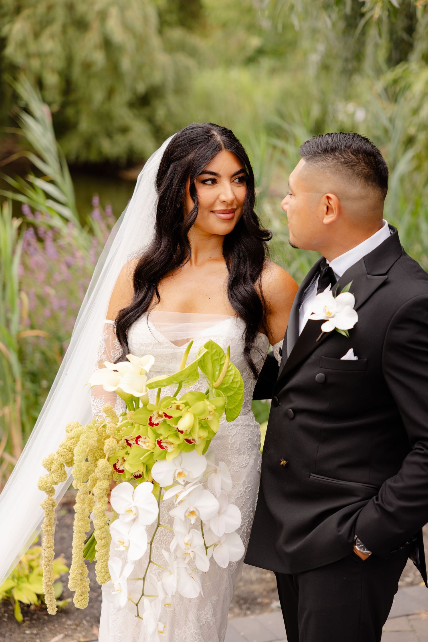 A romantic wedding photo series showing a couple in formal attire embracing among tall grass and flowers in an outdoor setting.