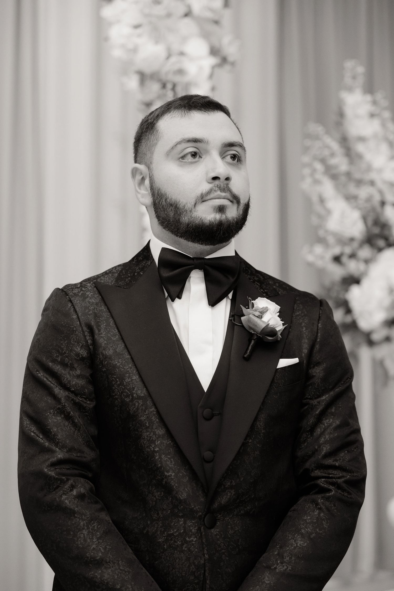 Close-up shots of groom in formal black tuxedo with white boutonniere.