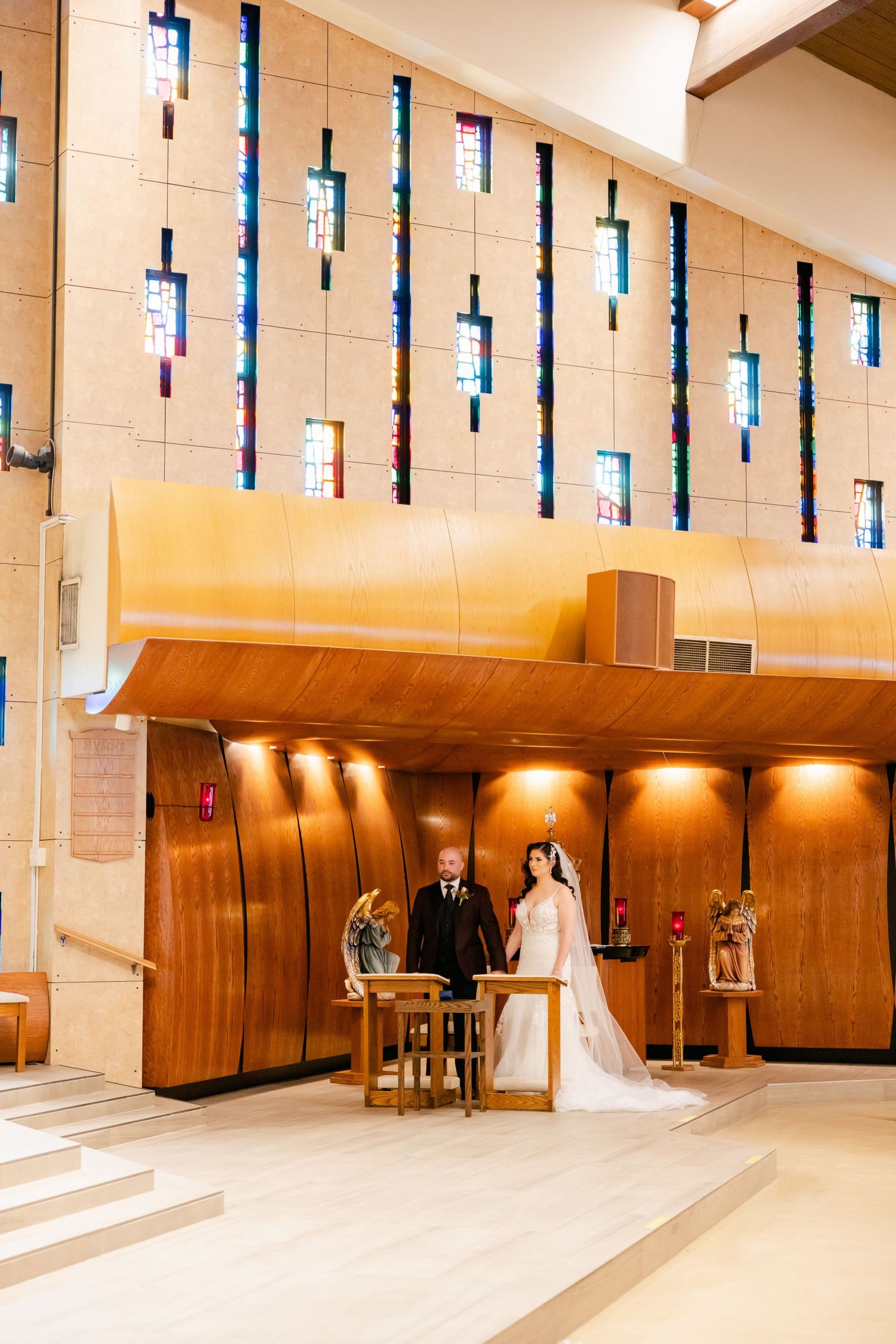 Church sanctuary with dramatic vertical stained glass windows and wooden accent walls.