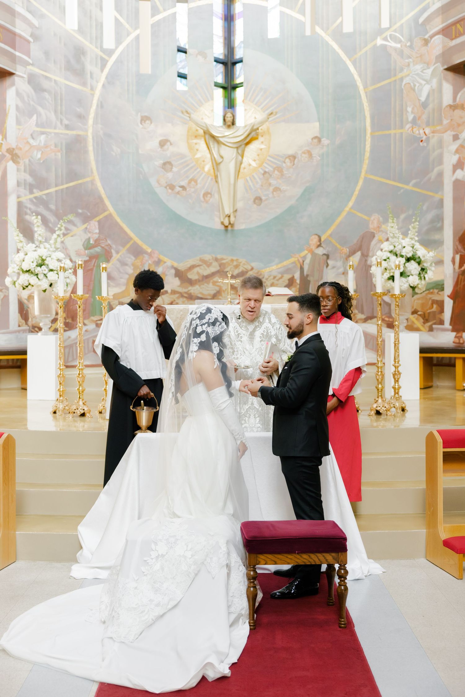 Wedding ceremony under ornate church altar with stained glass dove motif.