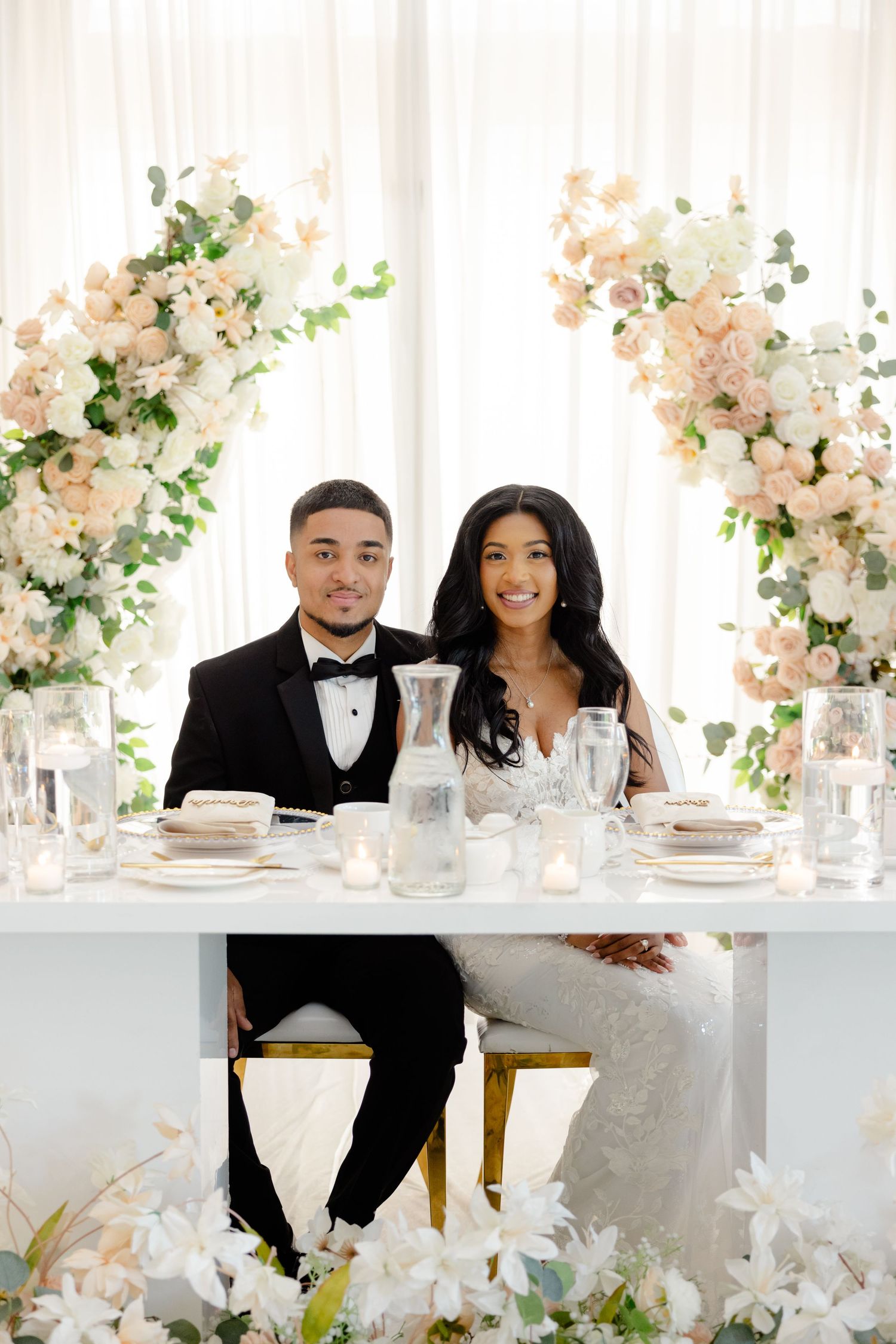 Elegant sweetheart table setup with blush floral arrangements and crystal table settings.