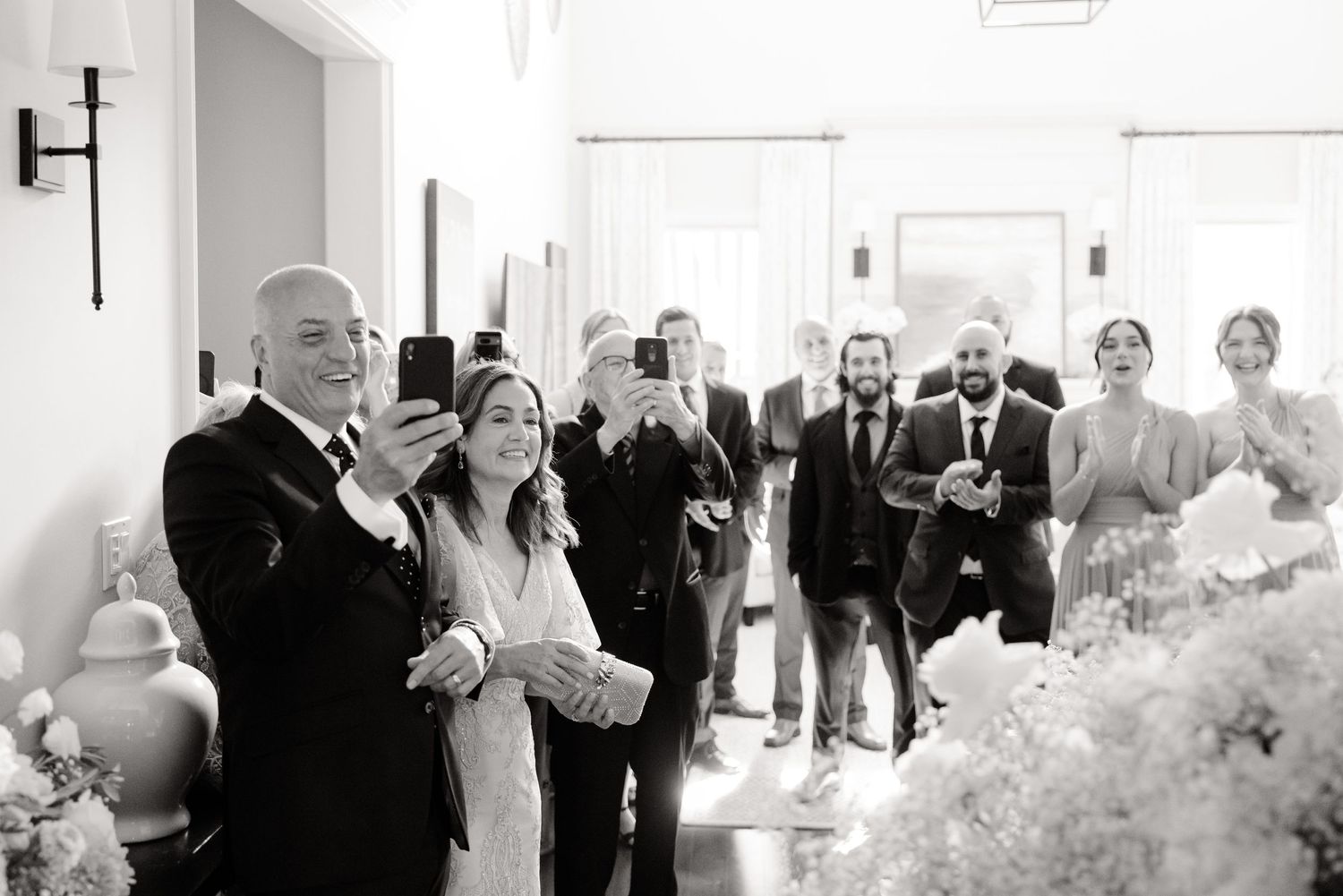 Black and white candid of wedding ceremony entrance with guests looking on.
