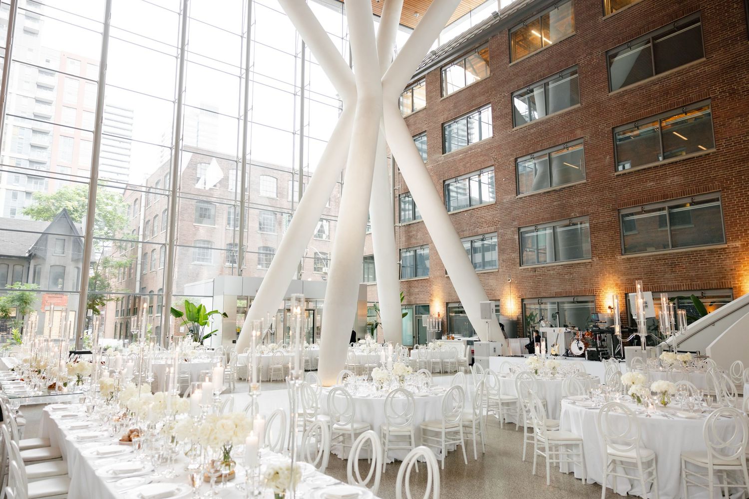 Modern wedding venue interior with white architectural columns and elegant table settings.
