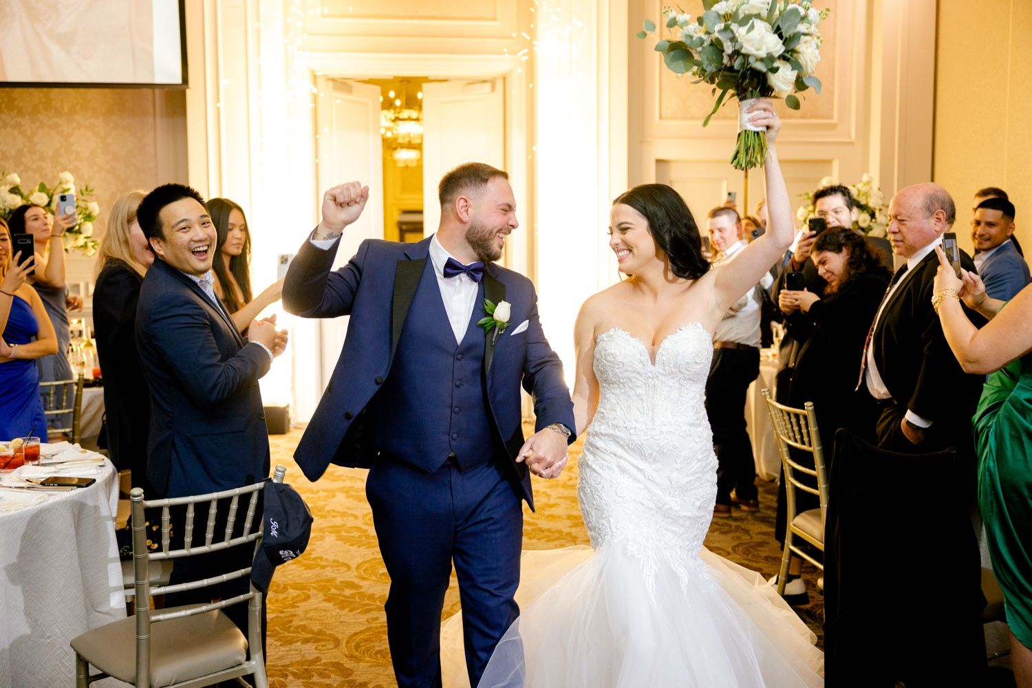 Wedding reception entrance with guests cheering and celebrating.