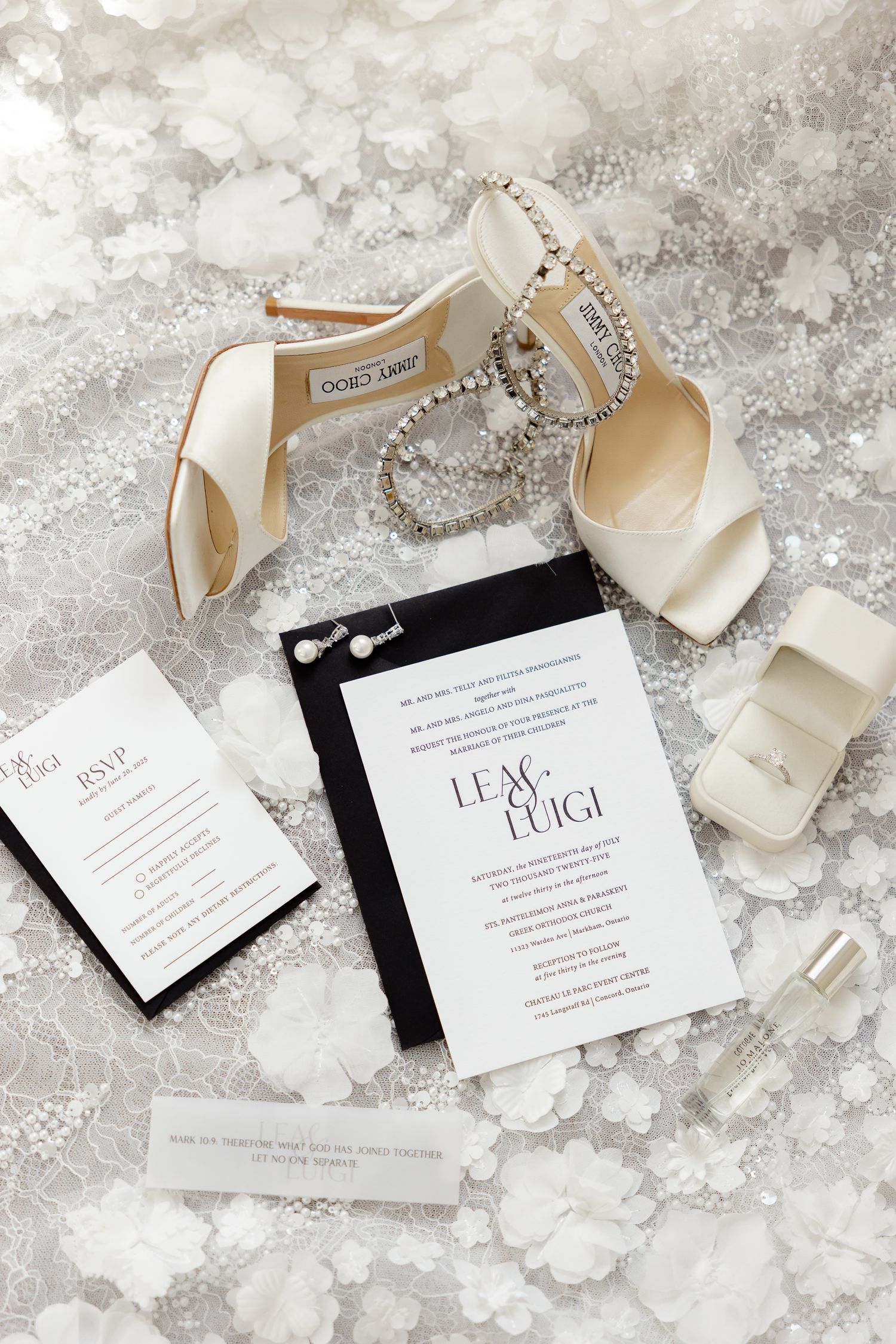Elegant wedding details including white Jimmy Choo shoes, pearl jewelry, and black and white invitations on marble surface.