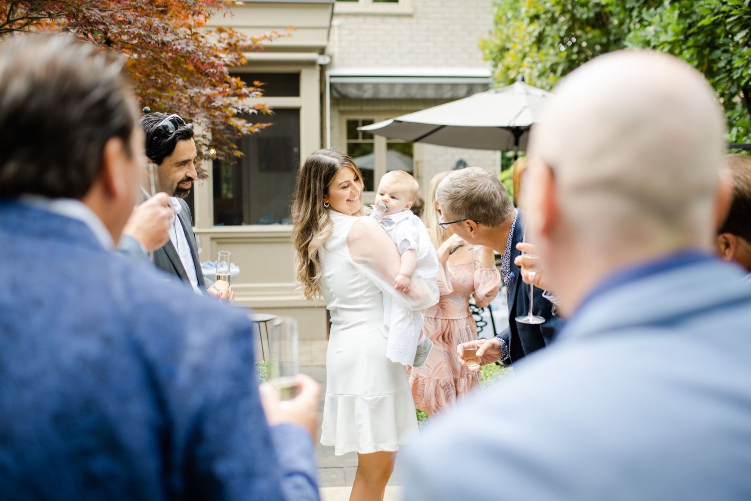 Outdoor celebration gathering with guests mingling in a garden setting.