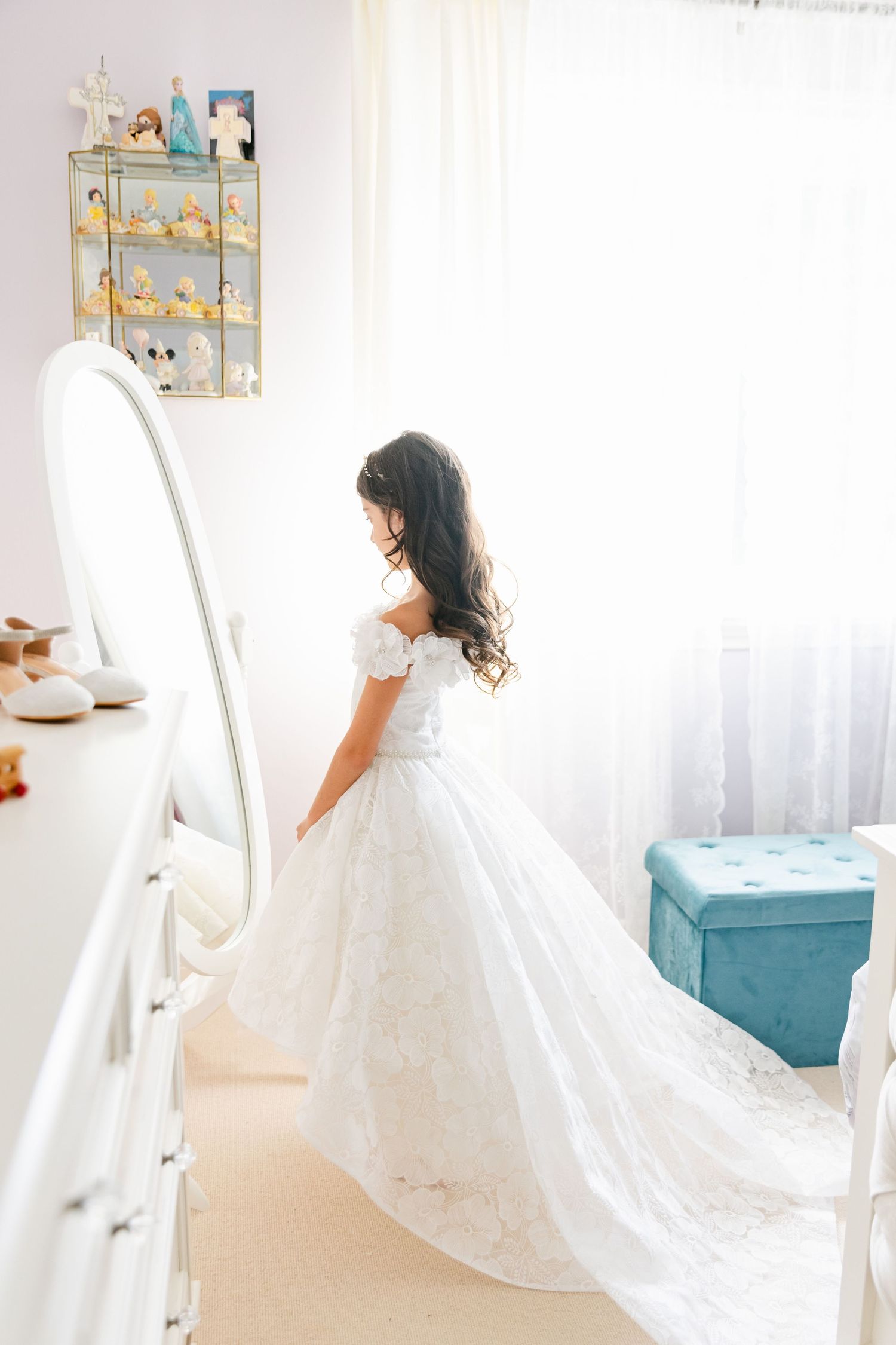 Side view of flowing white wedding dress captured in full-length mirror.