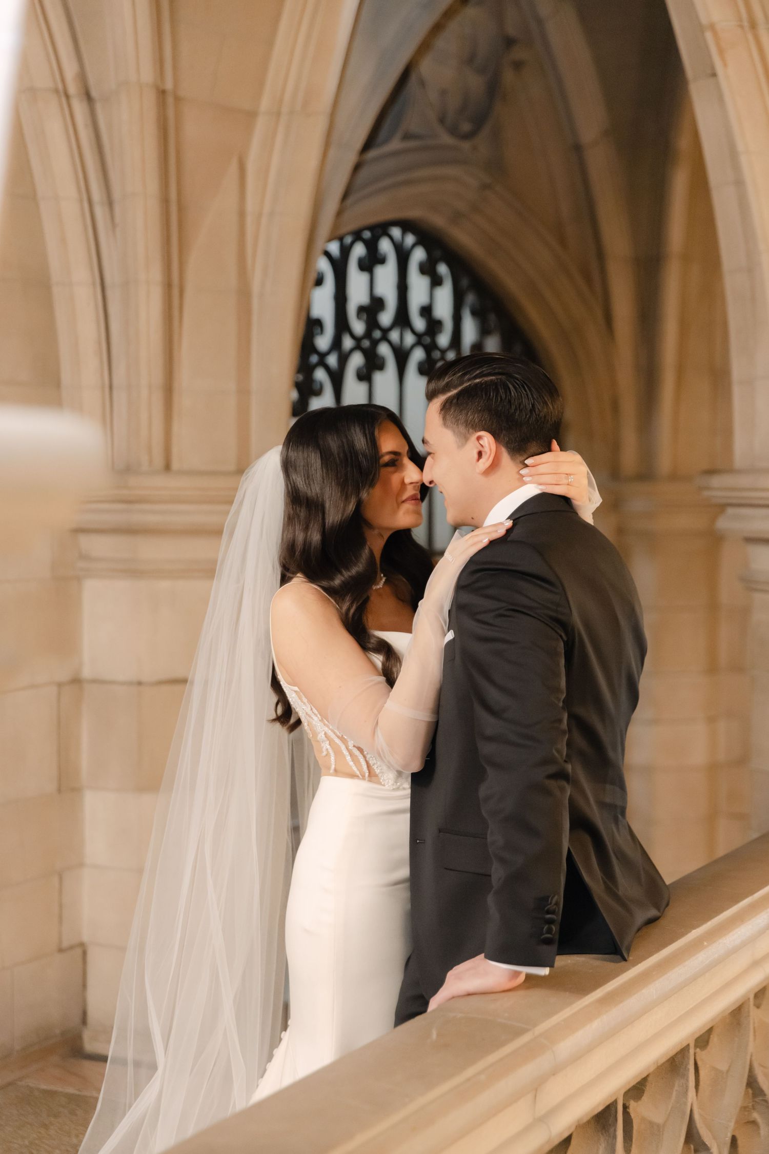 Romantic wedding portrait on grand staircase with Gothic architectural details.