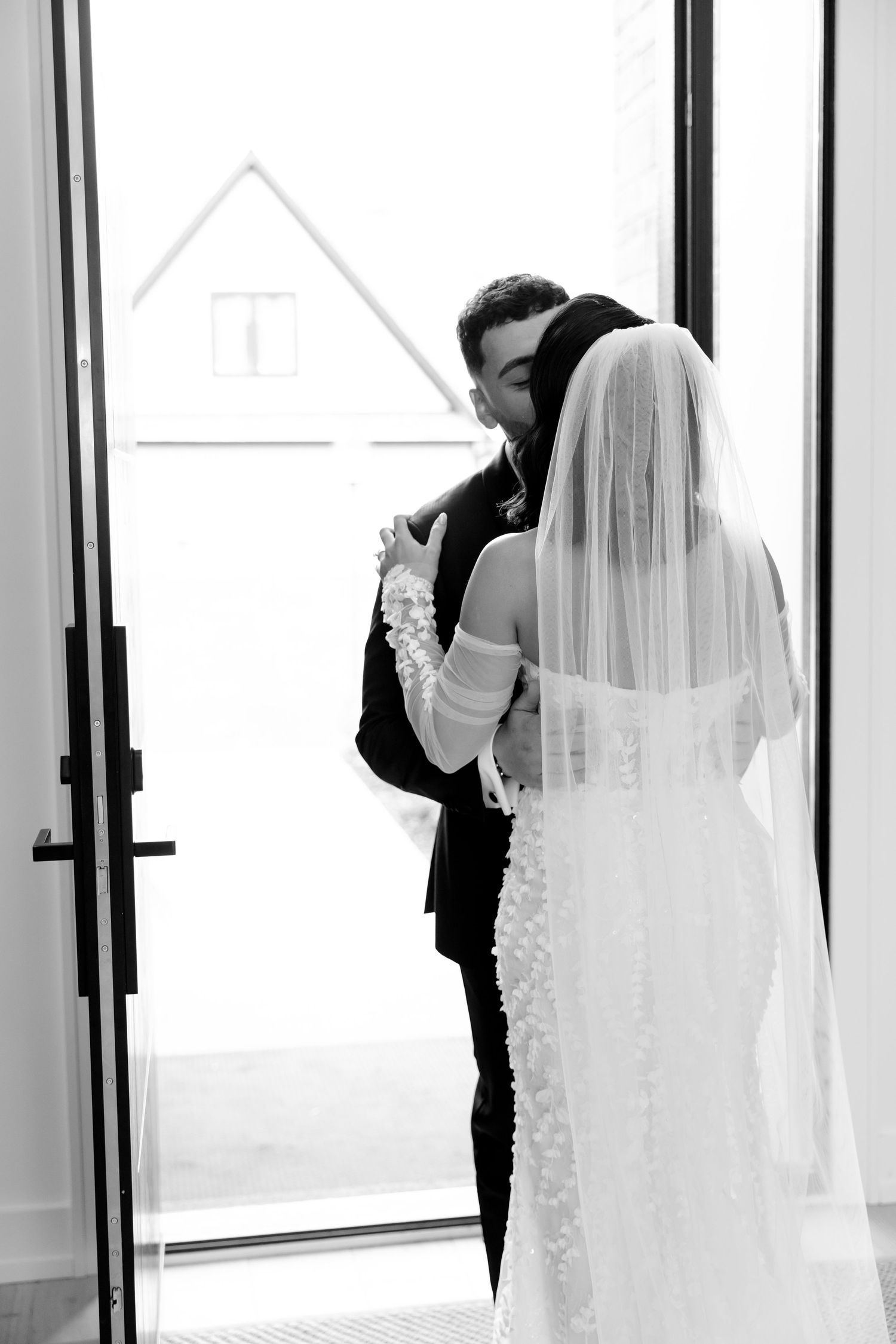 A romantic black and white capture of newlyweds sharing their first look moment.