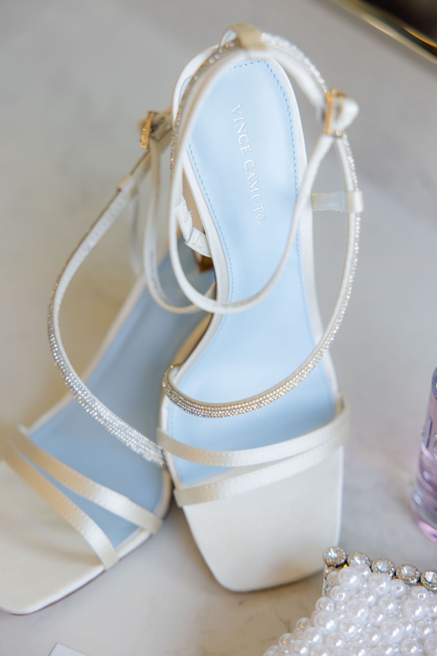 Elegant white bridal sandals with rhinestone details and delicate straps.