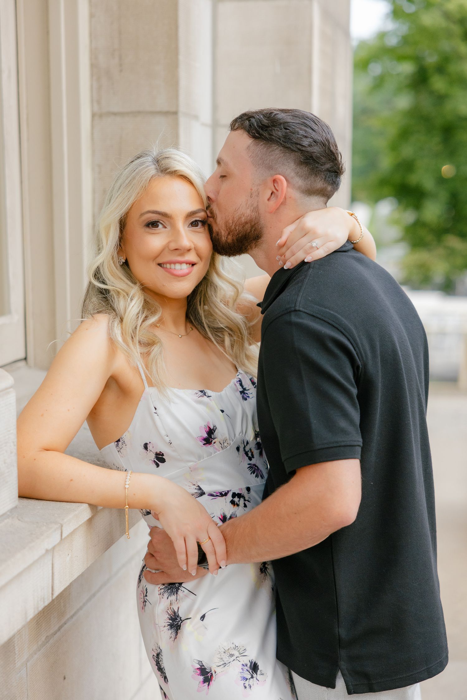 A sweet moment shared between a couple against elegant stone architecture.