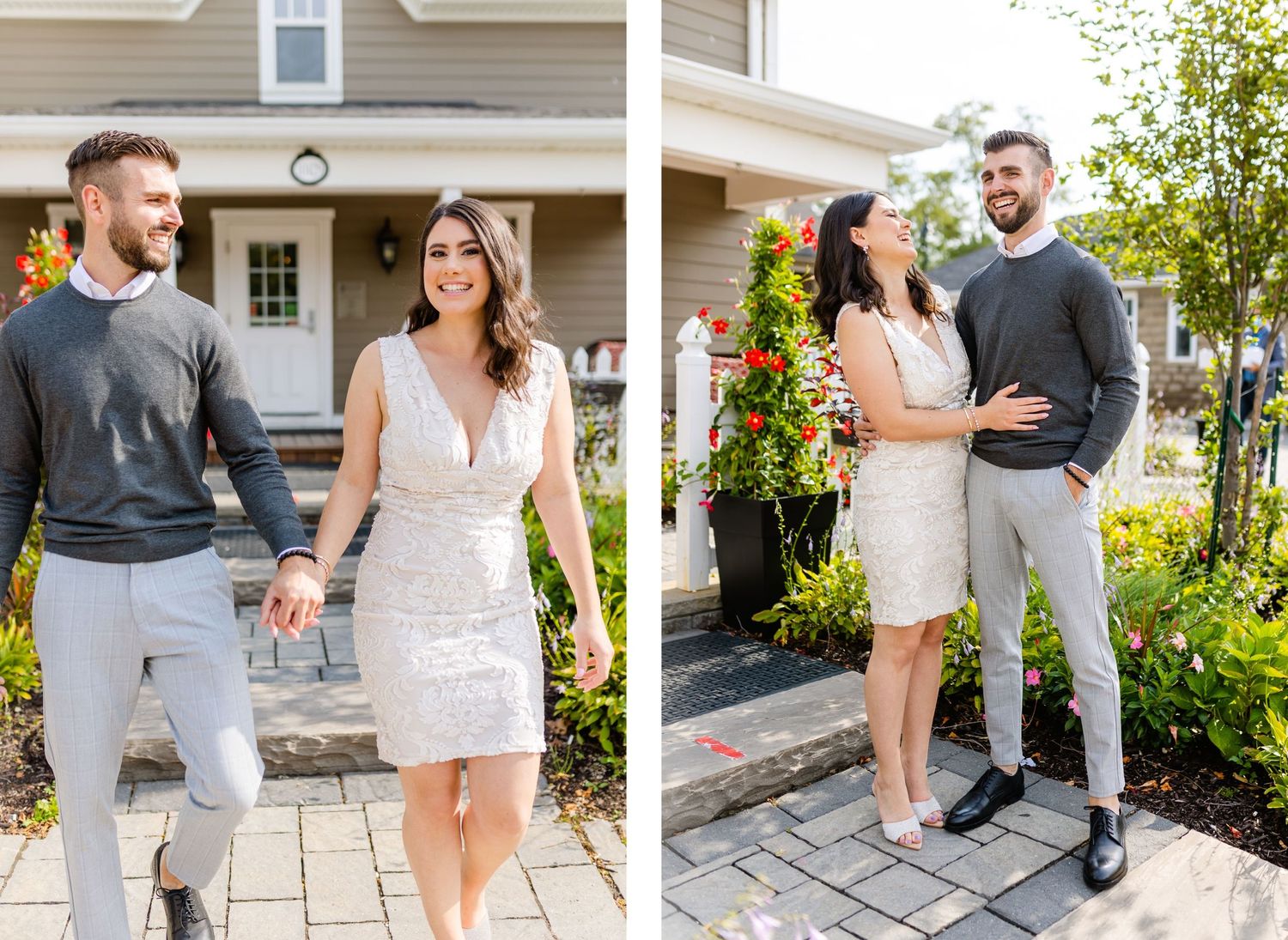 A couple in semi-formal attire poses together on stone steps outside a house with blooming flowers.