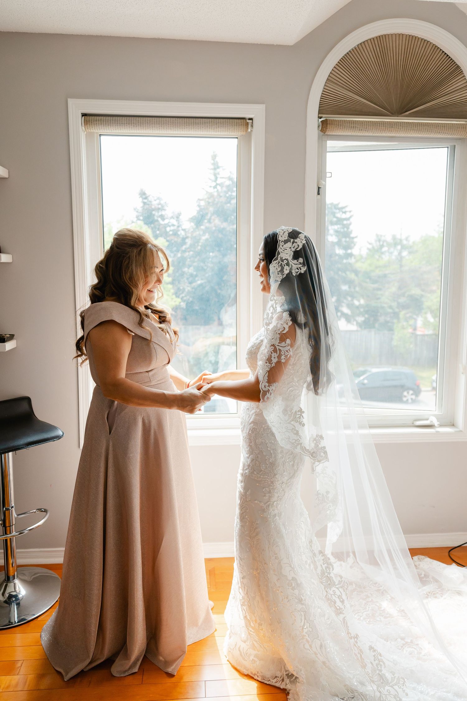 Tender moment between two people during wedding preparations in a sunlit room.
