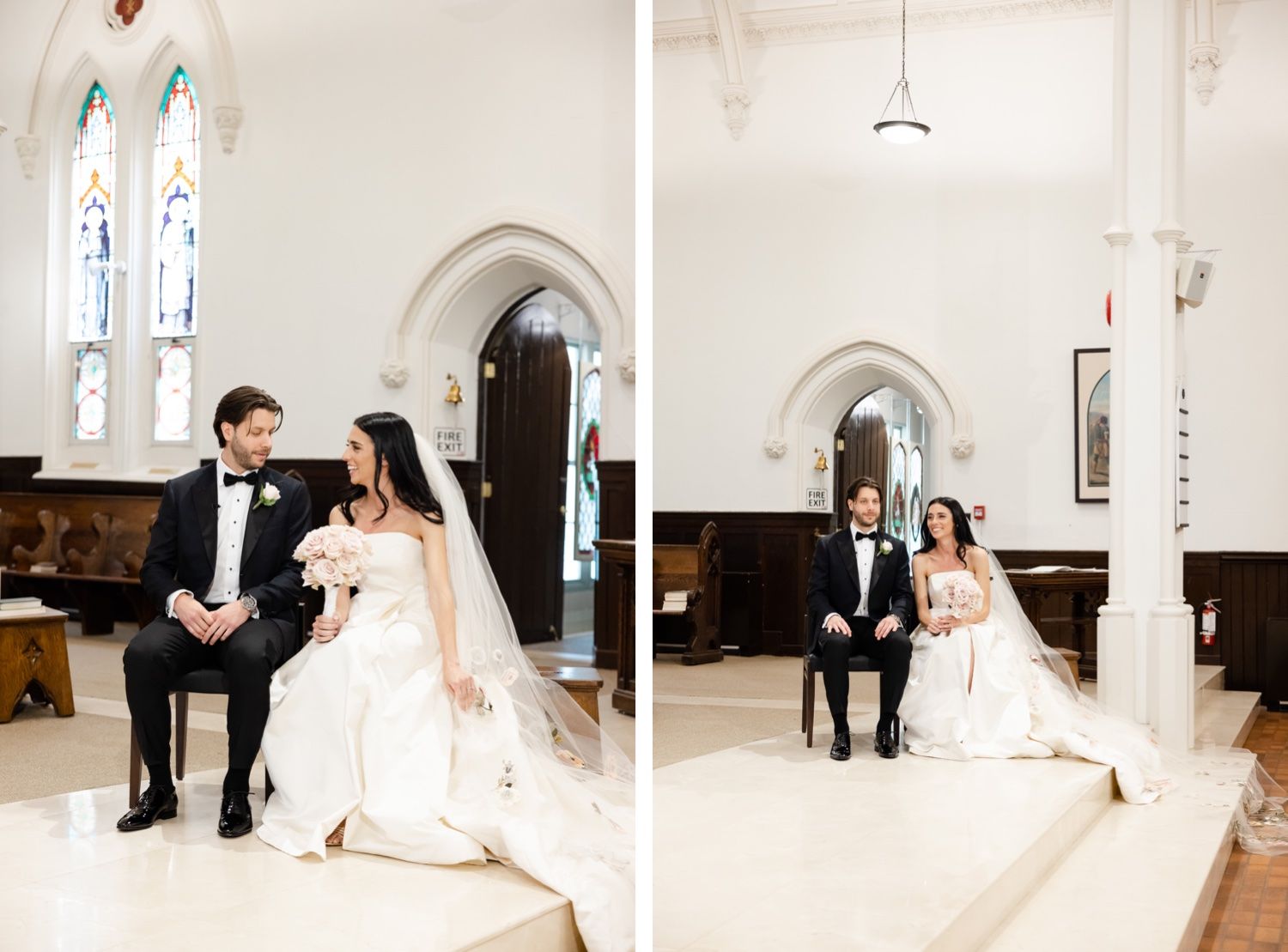 Wedding couple seated together in front of arched church windows with classic architectural details.