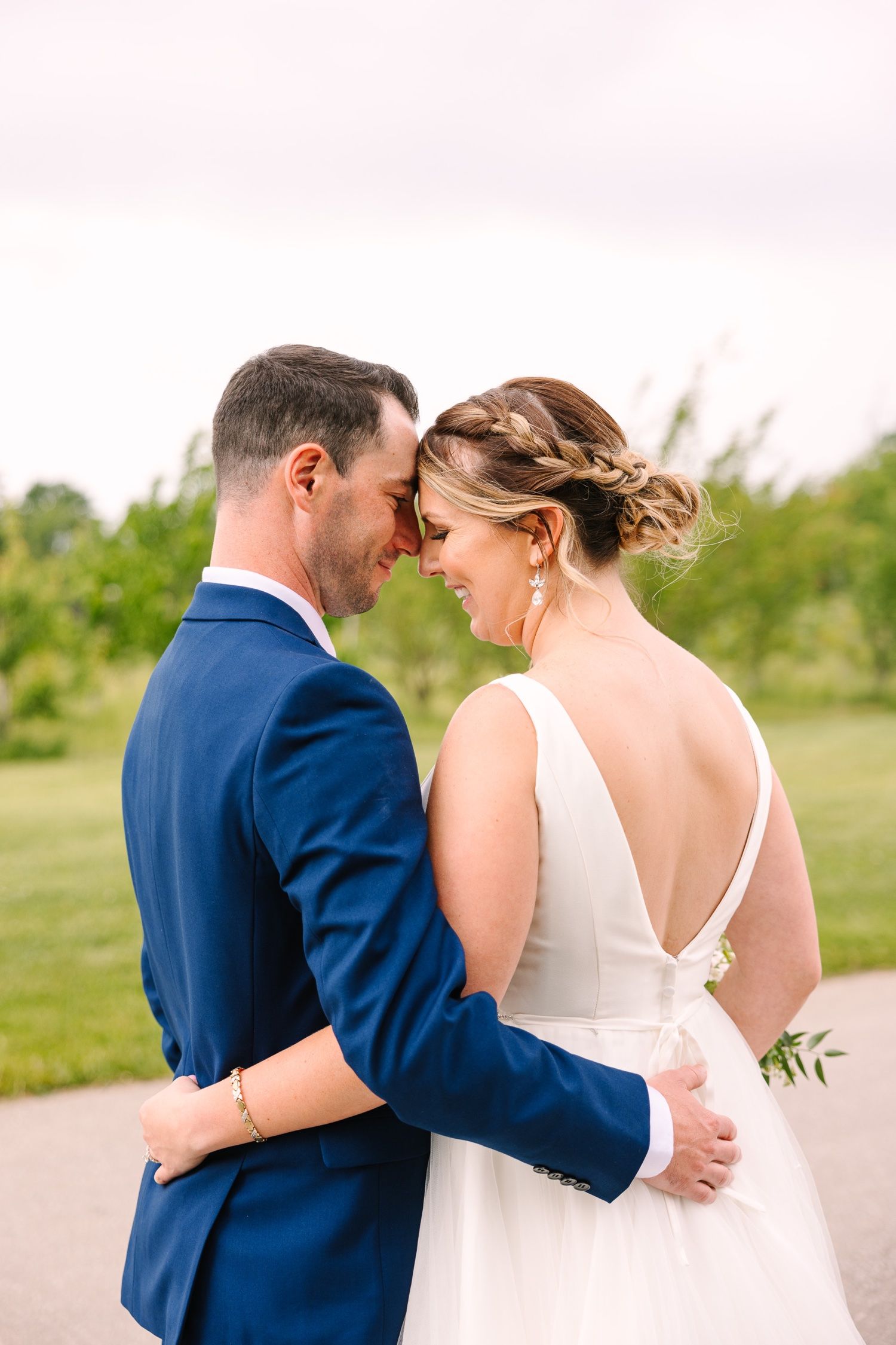 Intimate wedding moment captured as couple shares a tender embrace on a garden path.