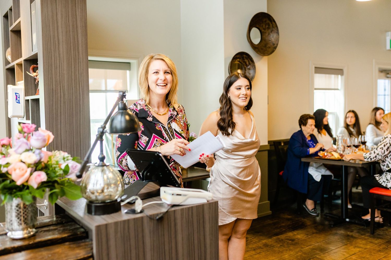 Celebration event in a modern venue with floral arrangements and wood accents.