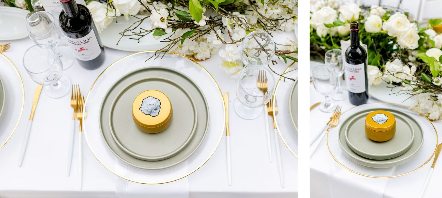 Place setting with gray plates, gold dessert and white floral centerpiece at wedding reception.