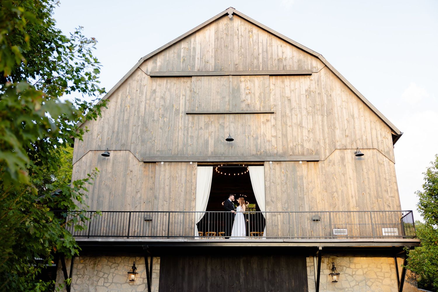 Rustic barn wedding venue with natural wood siding and dramatic architectural details.
