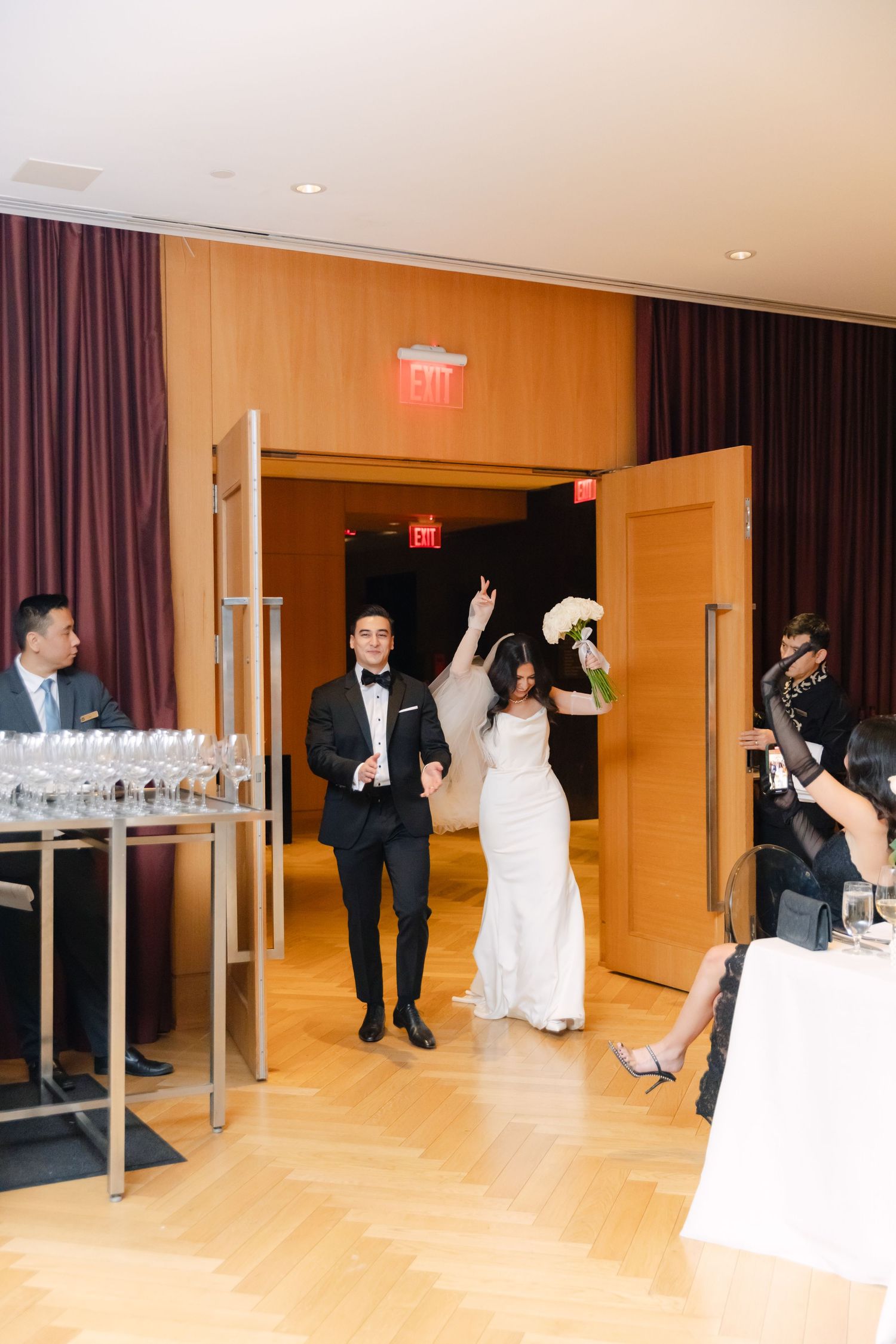 Wedding reception entrance with champagne table and elegant wood paneled walls.