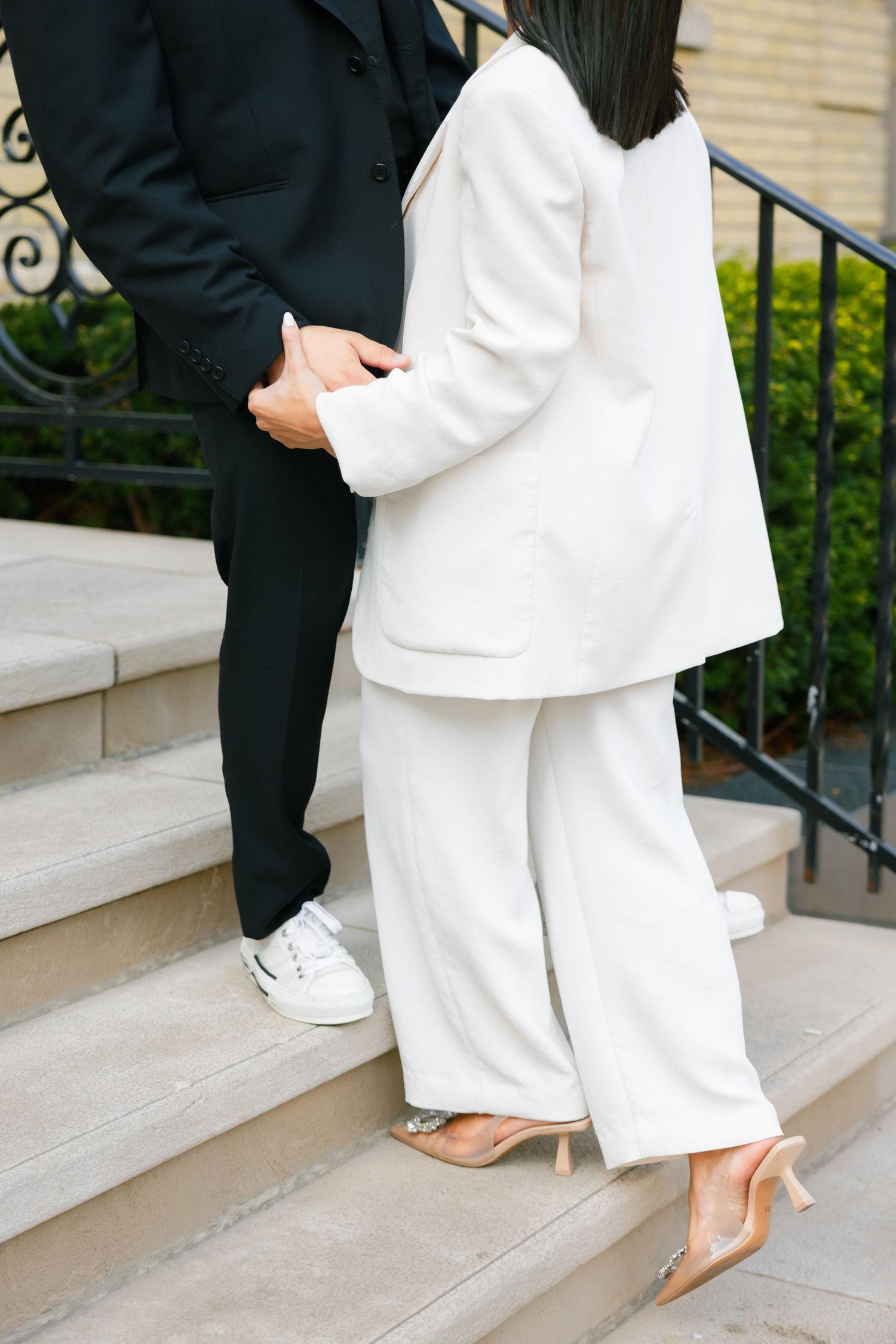 Detail shot of two people in black and white outfits standing on stone steps.