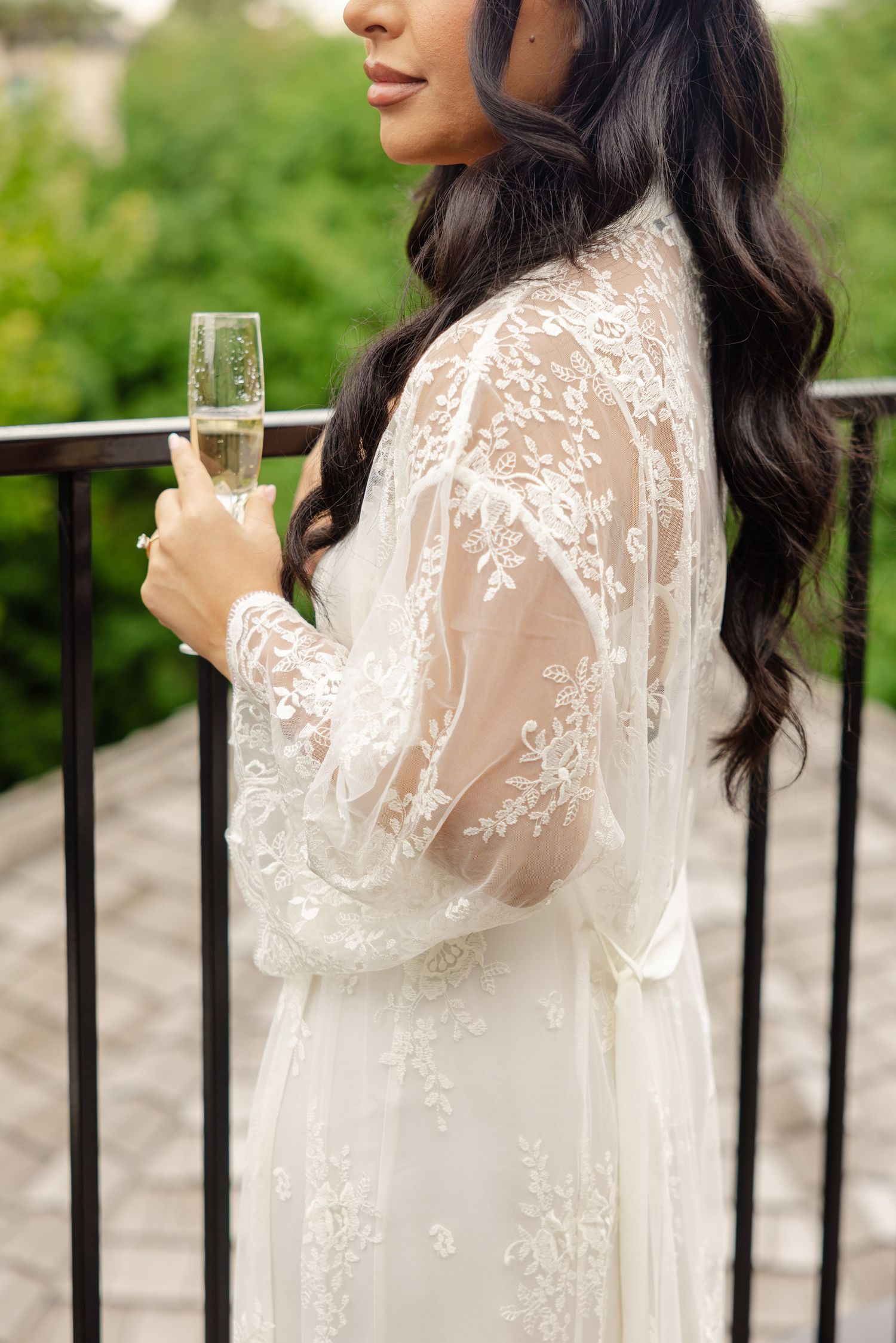 A series of close-up shots showing a white lace dress and champagne glass against an outdoor balcony railing.