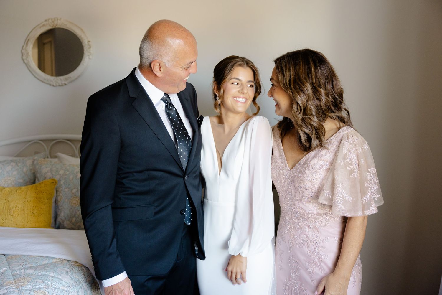 Candid family moment during wedding preparations in a bright indoor setting.