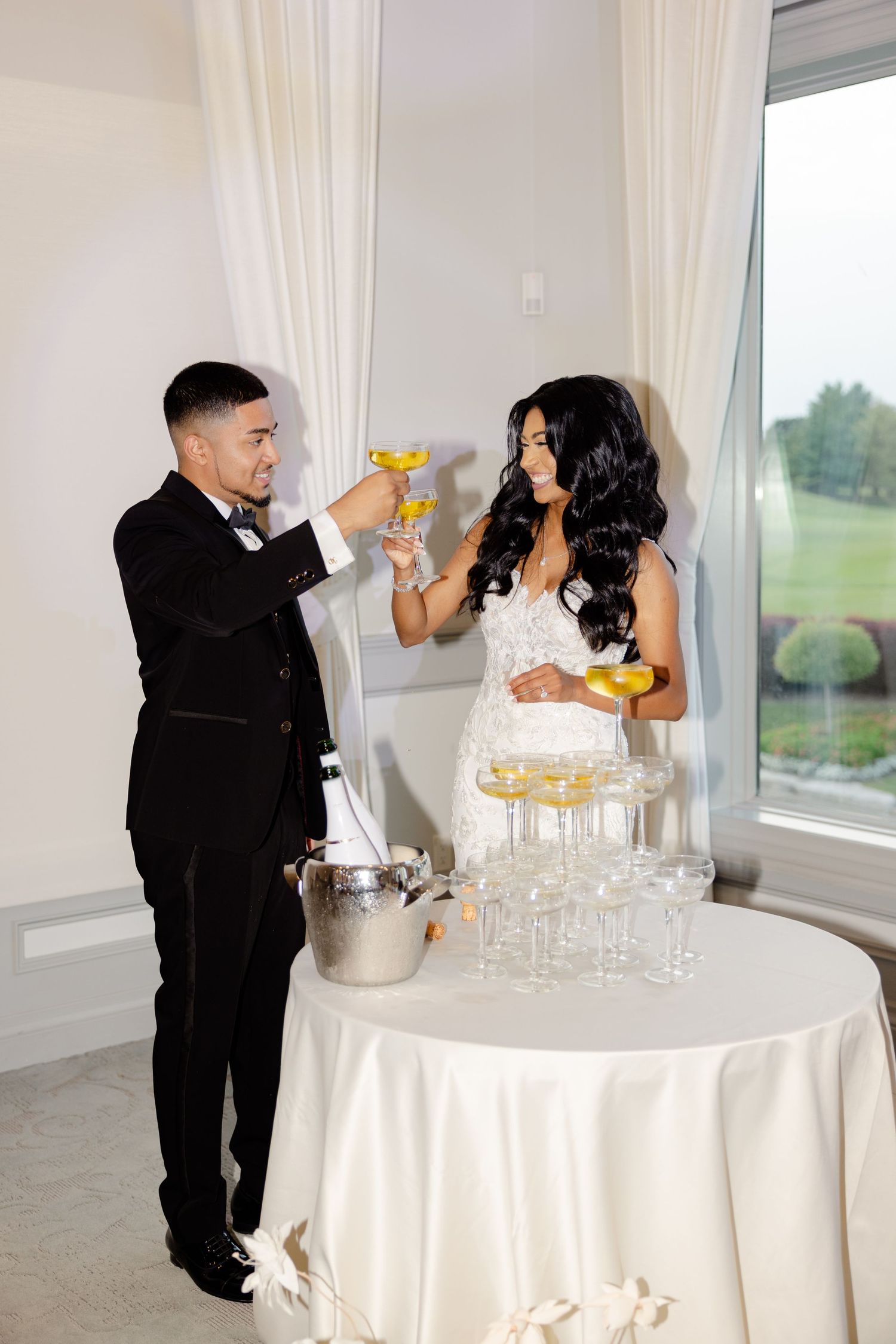 A couple raises their champagne glasses in a toast during their wedding reception.
